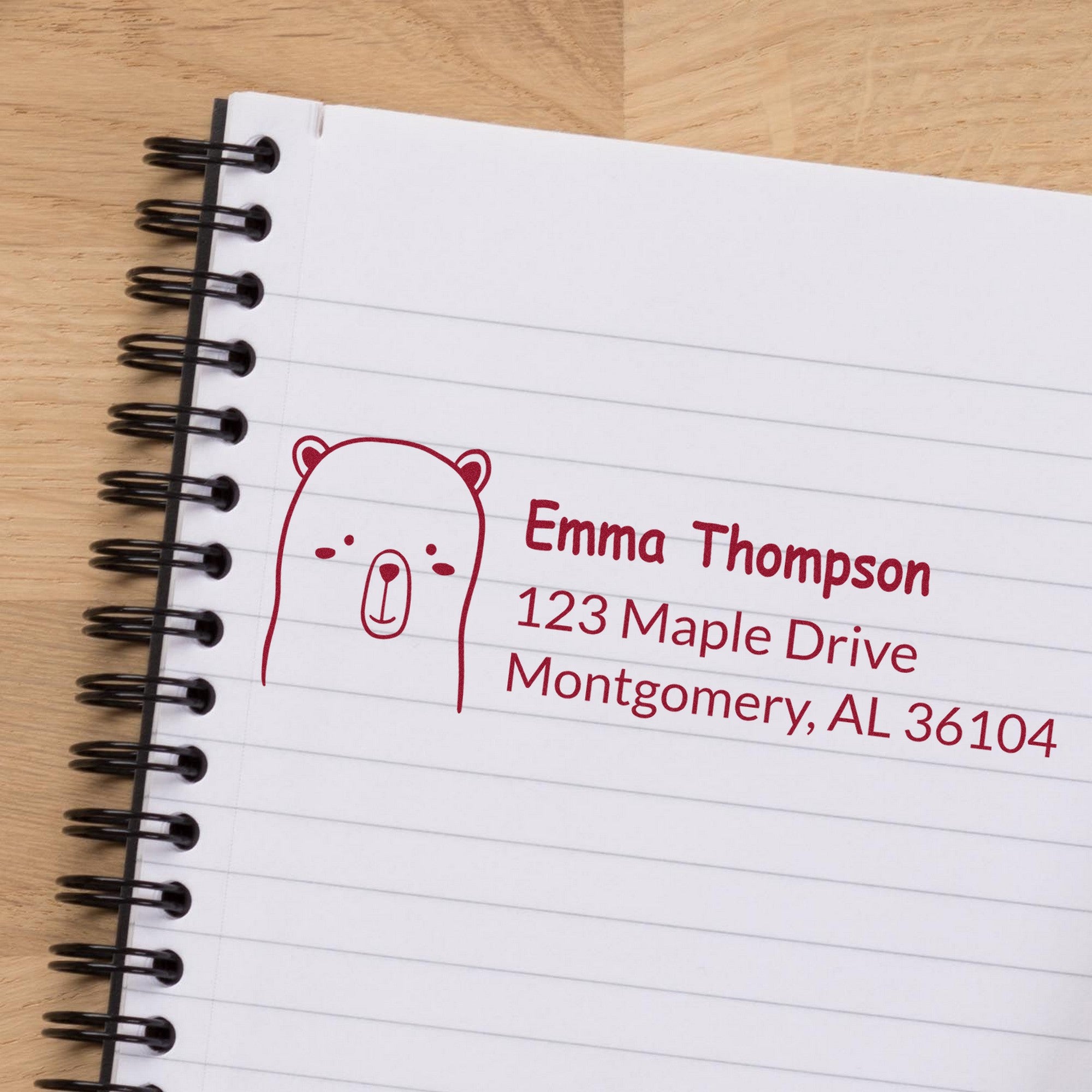 Wood Handle Adorable Bear Personalized Address Rubber Stamp on a notebook page, displaying a cute bear design with customizable return mail stamper details, including a name and address in red ink.