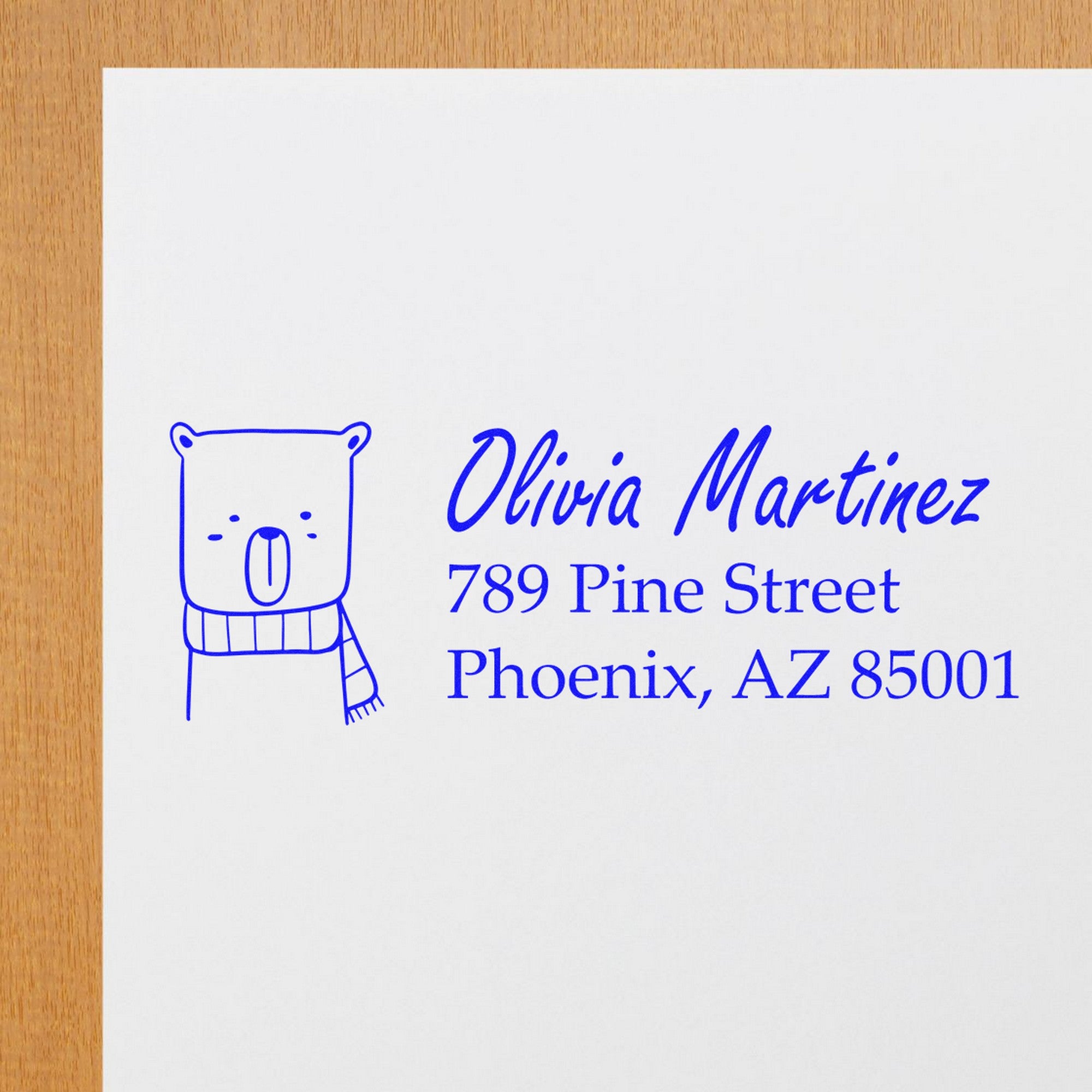 Wood Handle Snuggly Bear Personalized Name and Address Rubber Stamp on white paper, featuring a cute bear illustration with a scarf. Text reads "Olivia Martinez, 789 Pine Street, Phoenix, AZ 85001." Customizable Mailing Stamper for personal use.