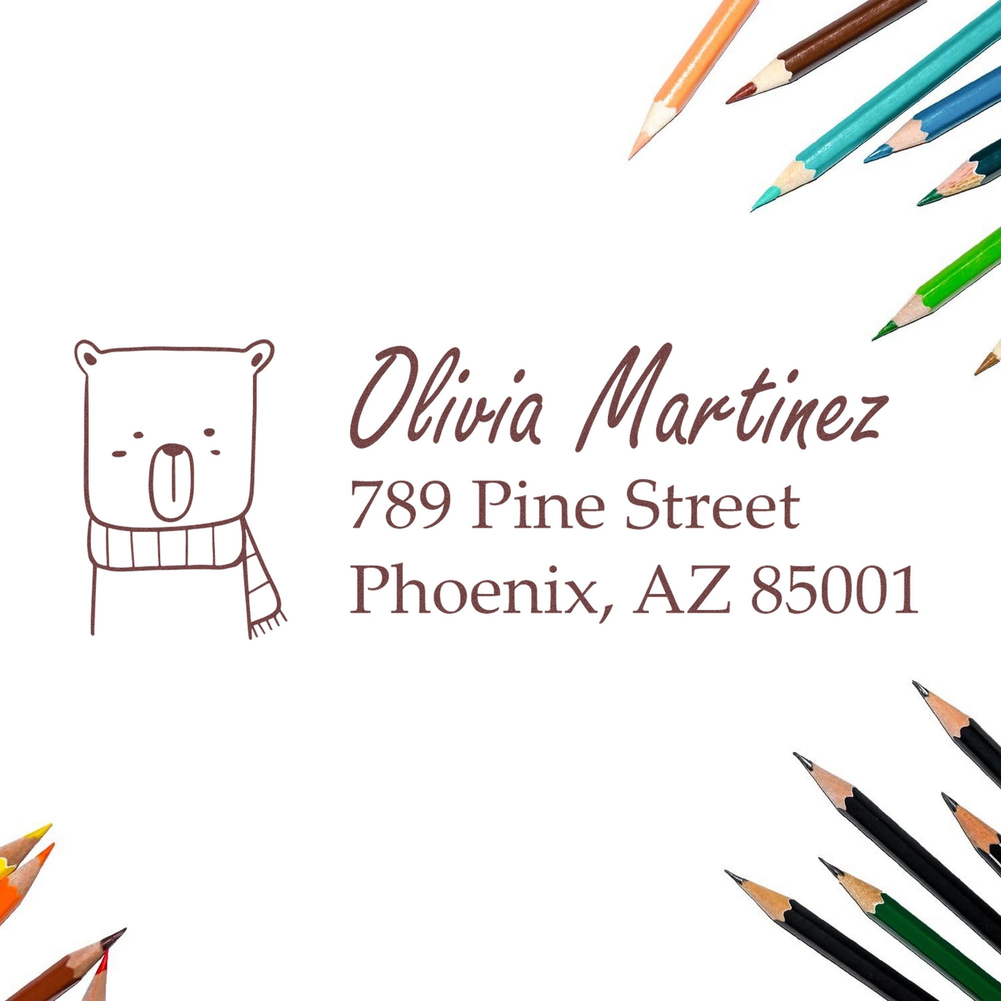 Image of a Wood Handle Snuggly Bear Personalized Name and Address Rubber Stamp imprint on paper, featuring a bear illustration and text: "Olivia Martinez, 789 Pine Street, Phoenix, AZ 85001." Surrounded by colored pencils. Personalizable Address Stamp.