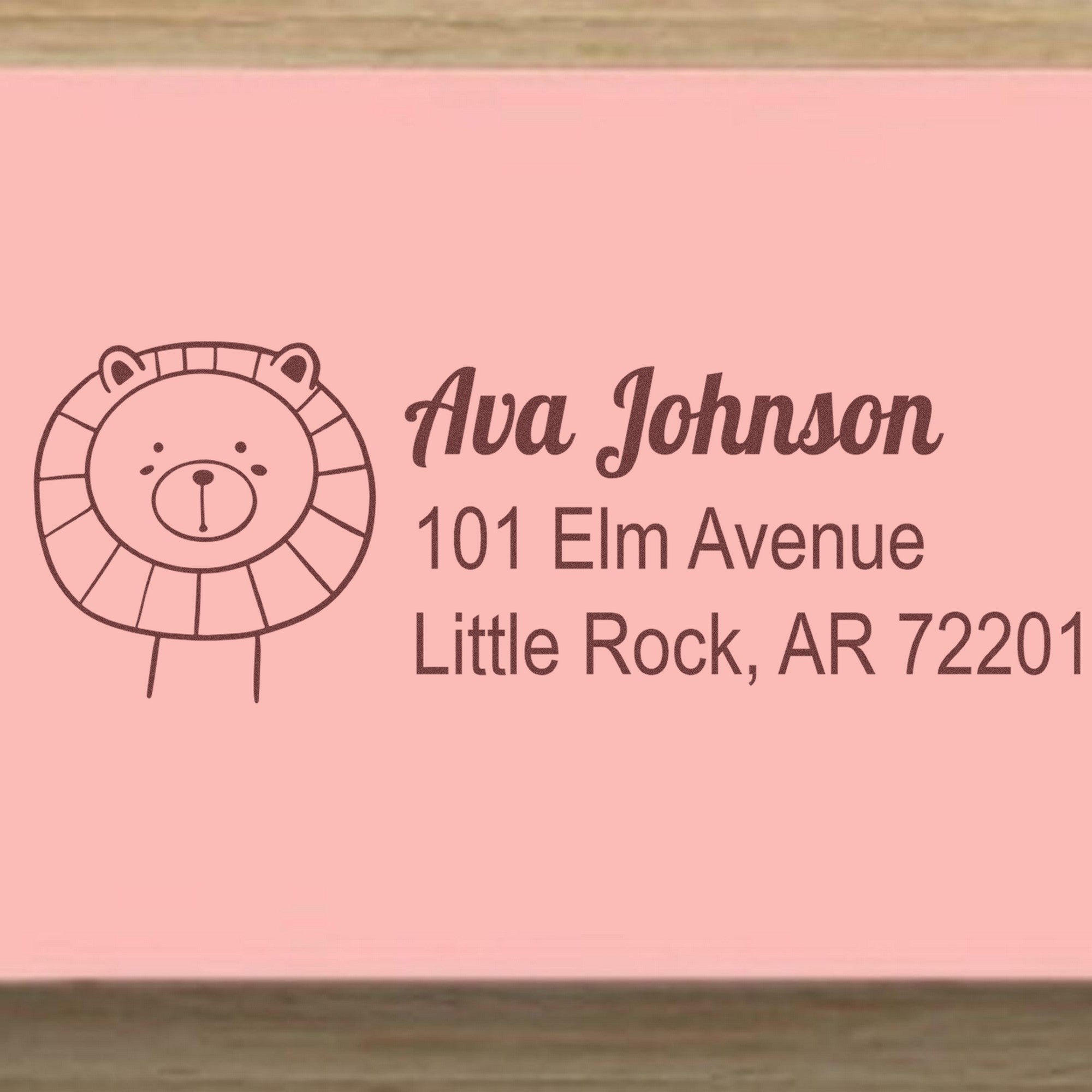 Wood Handle Lovable Lion's Lair Personalized Mailing Rubber Stamp featuring a cute lion illustration and customizable address. Personalizable Address Stamp shown with the name Ava Johnson and address 101 Elm Avenue, Little Rock, AR 72201.