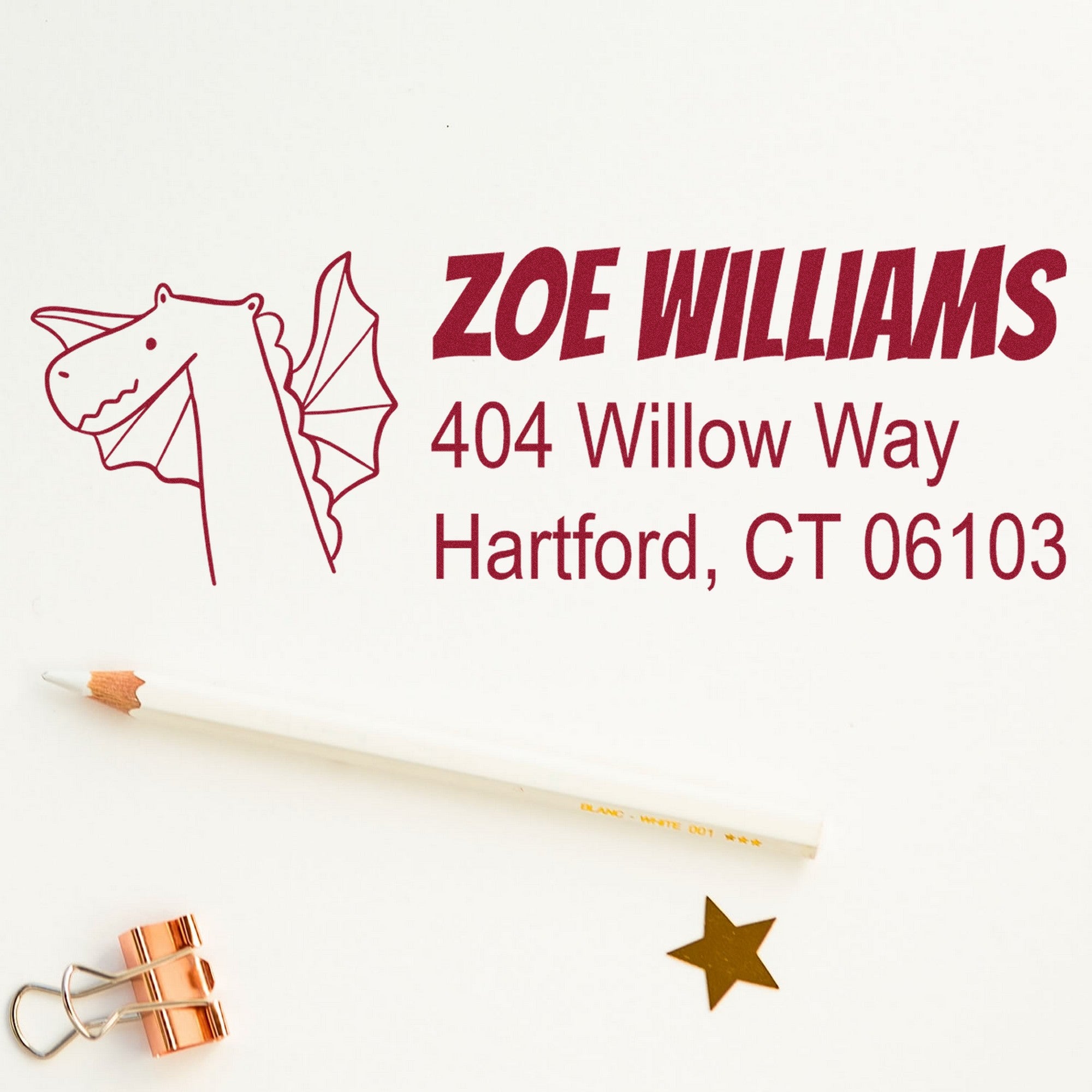 PSI Dragon Delight Handmade Address Pre-Inked Stamp featuring a dragon design and personalized address stamper with the name Zoe Williams, 404 Willow Way, Hartford, CT 06103. Includes a pencil, gold star, and copper clip on a white background.
