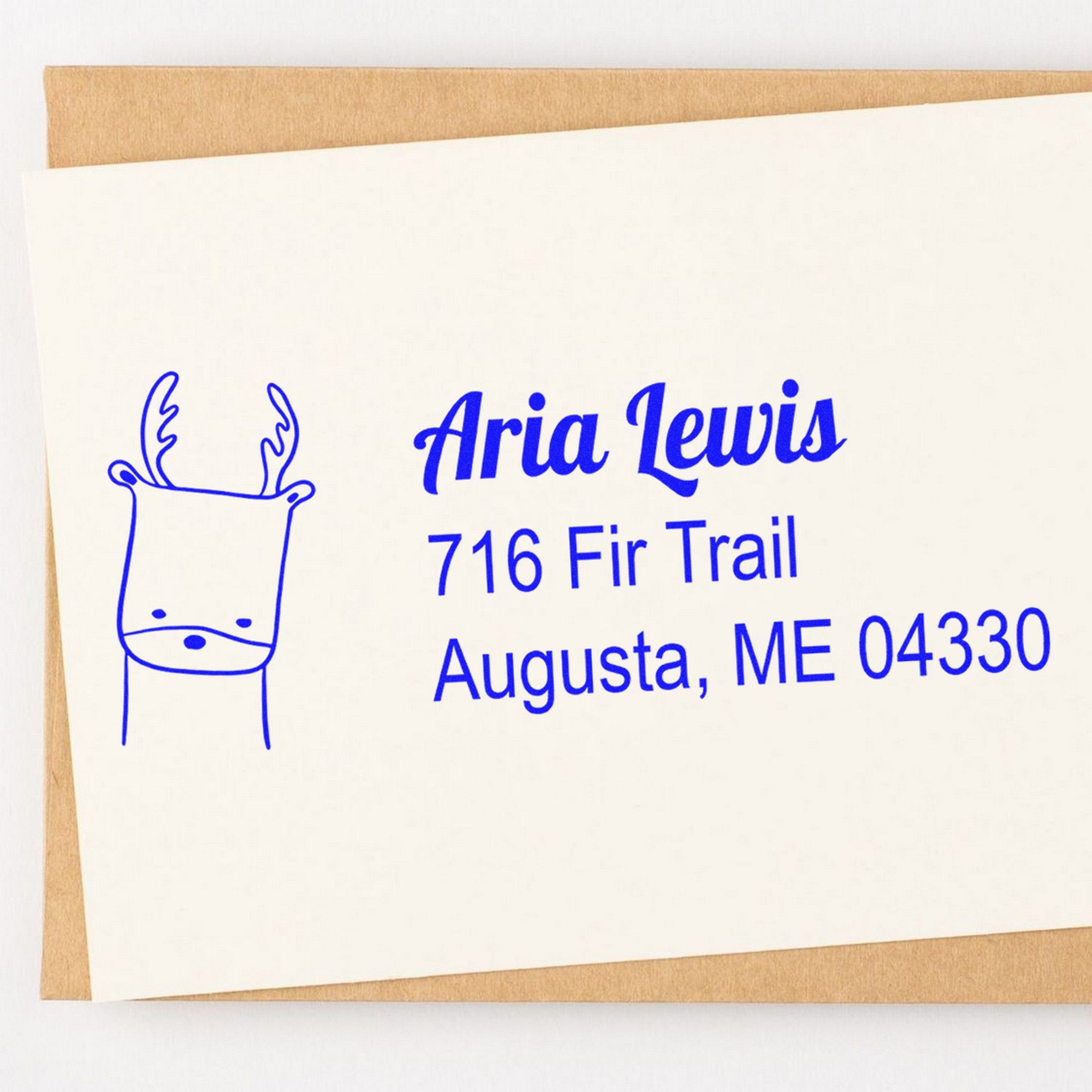 Wood Handle Darling Deer Custom Address Return Rubber Stamp on an envelope, featuring a blue deer illustration and custom-made home stamper text: "Aria Lewis, 716 Fir Trail, Augusta, ME 04330."