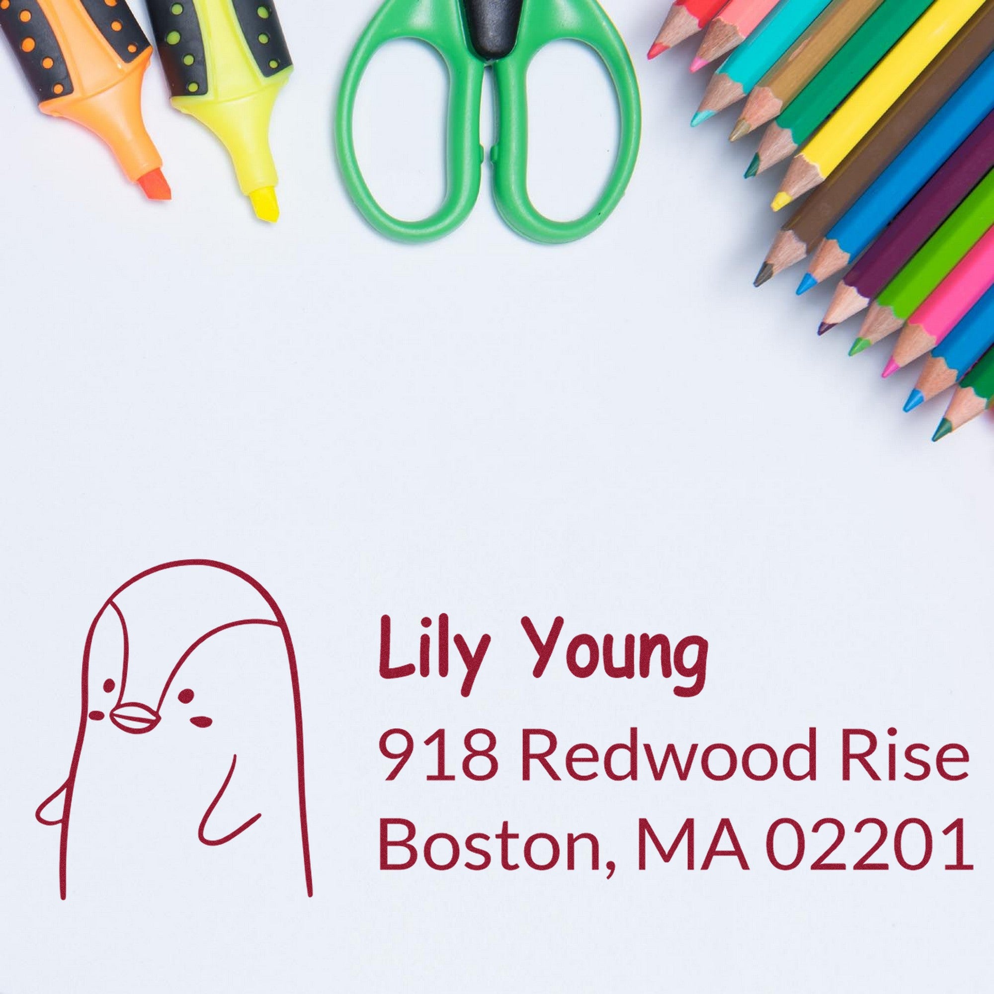 Wood Handle Perky Penguin Custom Mail Address Rubber Stamp with a penguin design and personalized home stamper details for Lily Young, 918 Redwood Rise, Boston, MA 02201. Surrounded by colorful pencils, scissors, and highlighters.