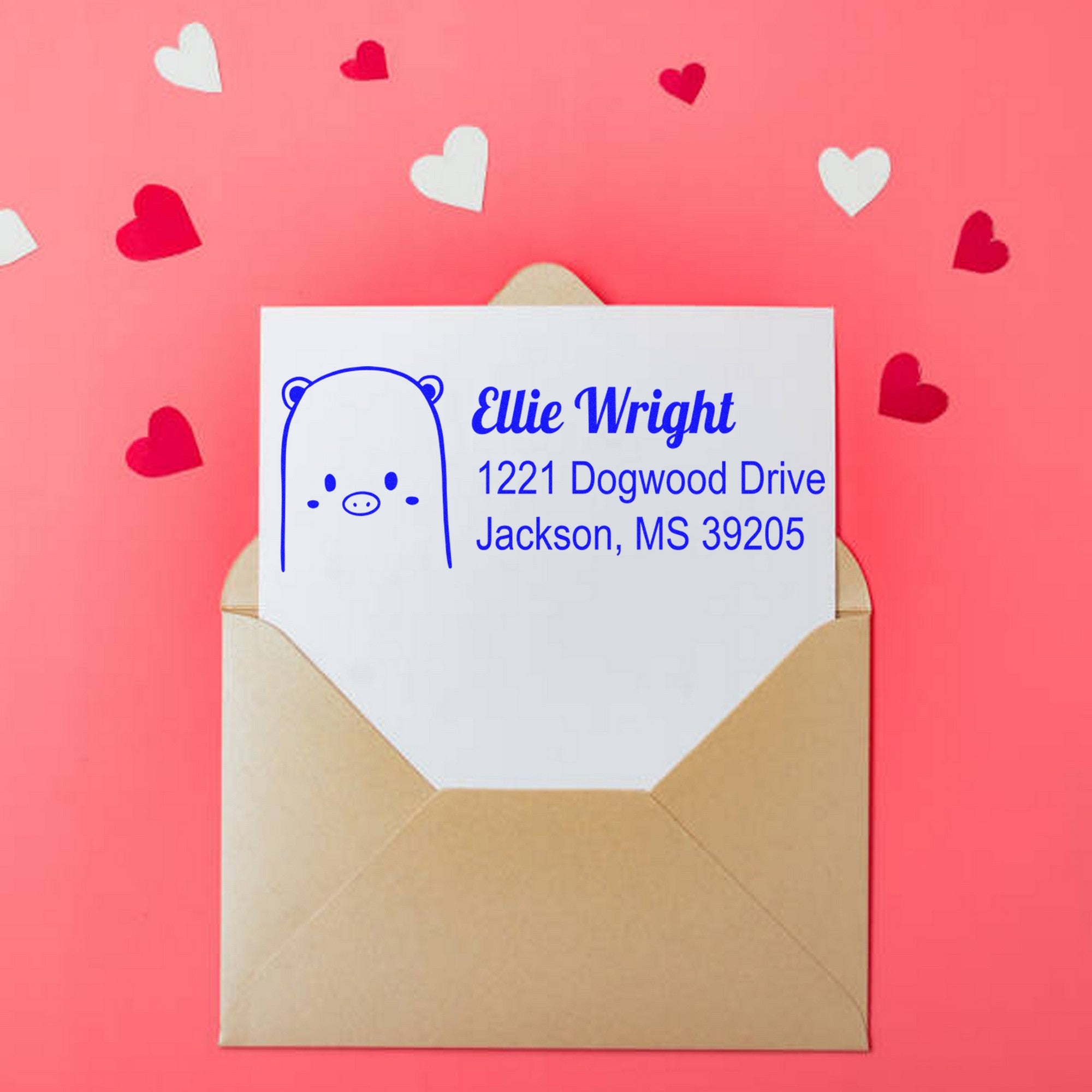 Wood handle beautiful bear custom address label rubber stamp on a personalized address stamp. The stamp is used on an envelope with a cute bear design and address details, surrounded by small red and white heart cutouts on a pink background.