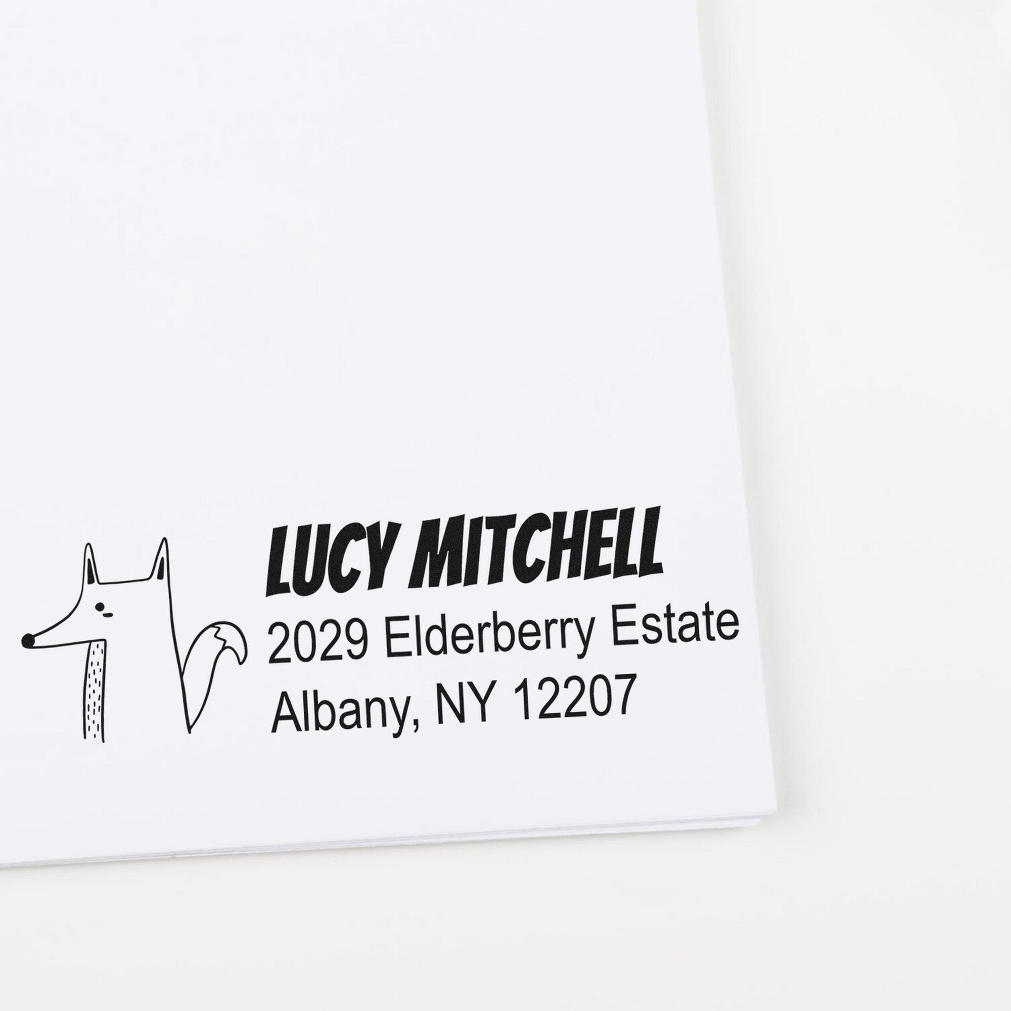 Finicky Fox Personalized Home Address For Envelopes Self-Inking Stamp featuring a custom-made address stamp with a fox illustration and the name "Lucy Mitchell" alongside an address in Albany, NY.