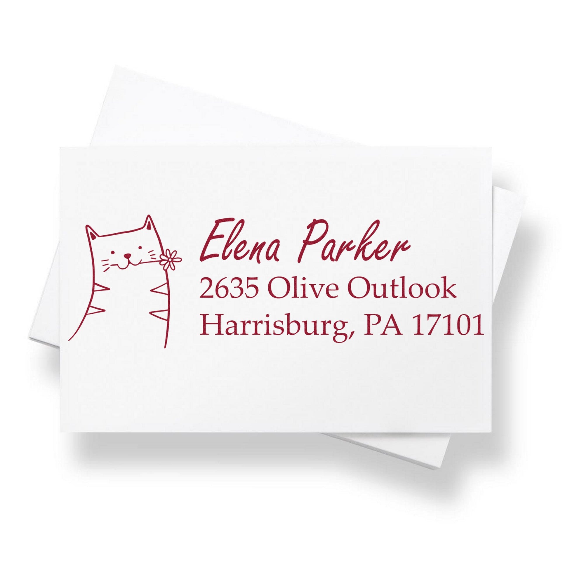 Wood handle fluffy feline handmade return address rubber stamp on a white card with red ink. The custom-made home stamper features a cute cat design and the name "Elena Parker" with an address in Harrisburg, PA.