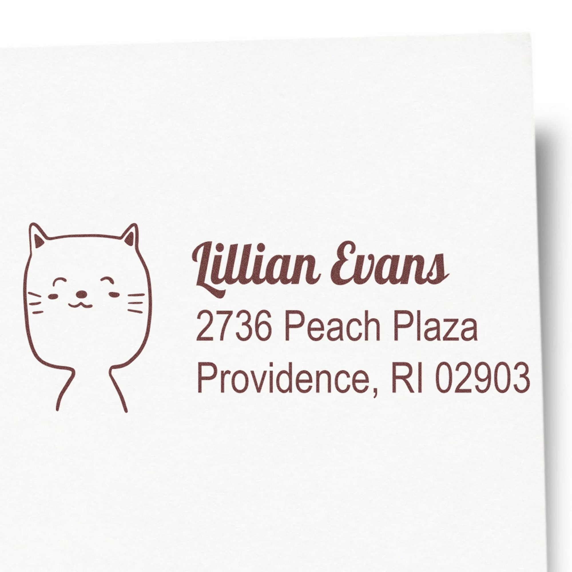 Image of a Happy Cat Custom Home Address Self-Inking Stamp featuring a cute cat illustration and the text "Lillian Evans, 2736 Peach Plaza, Providence, RI 02903." This Custom-Made Return Mail Stamp is designed for personalized mailing needs.