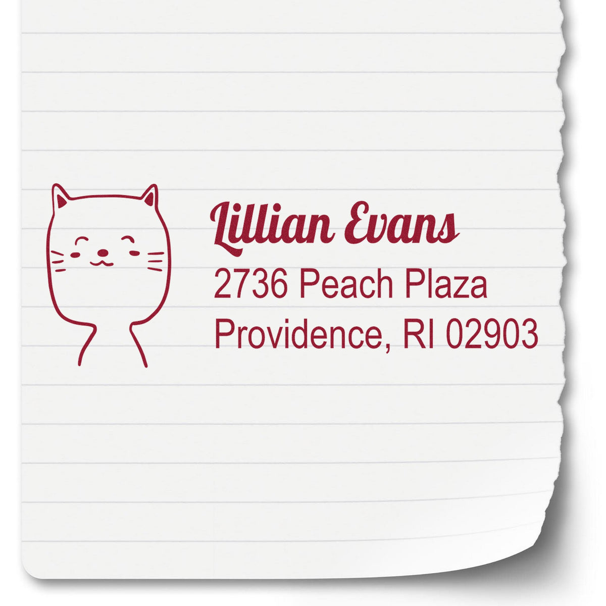 Slim Pre-Inked Happy Cat Handmade Address Label Stamp on lined paper, featuring a cute cat illustration and personalized home stamp with the name Lillian Evans and address 2736 Peach Plaza, Providence, RI 02903 in red ink.