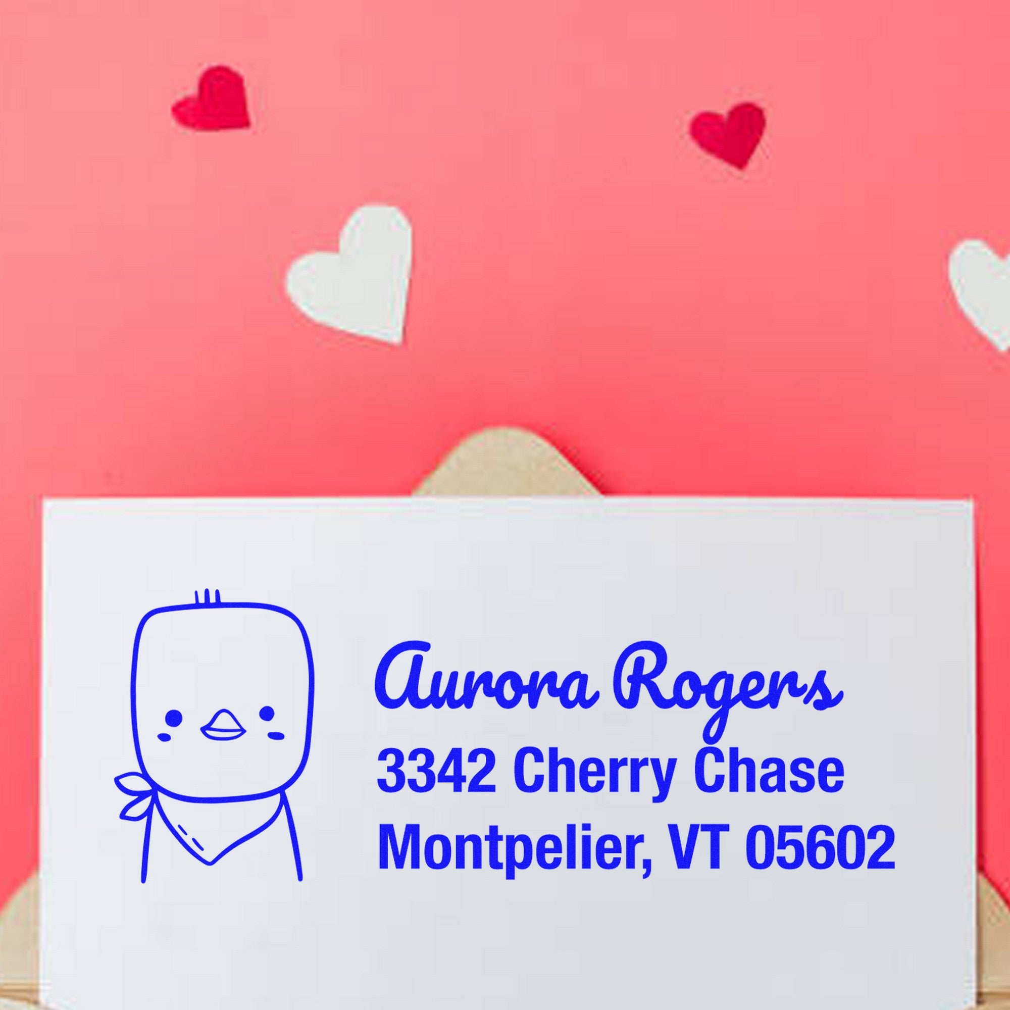 Wood handle cute chick handmade mail address rubber stamp on an envelope with customizable new address stamper design. The envelope displays a cartoon chick and the address "Aurora Rogers, 3342 Cherry Chase, Montpelier, VT 05602" against a pink background with heart shapes.
