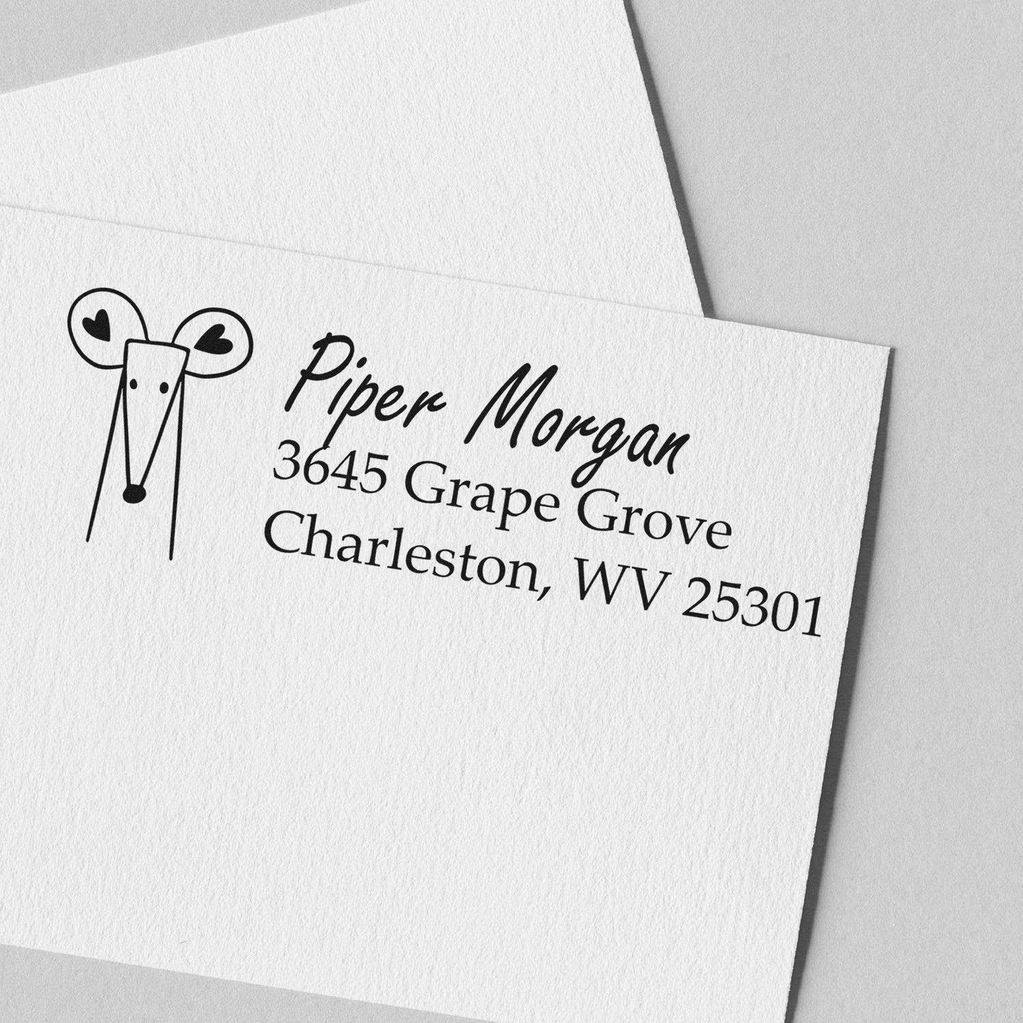 Mighty Mouse Customized Name and Address Self-Inking Stamp on white paper, featuring a mouse illustration with heart-shaped ears. Text reads "Piper Morgan, 3645 Grape Grove, Charleston, WV 25301." Ideal for a Custom Address Stamper.