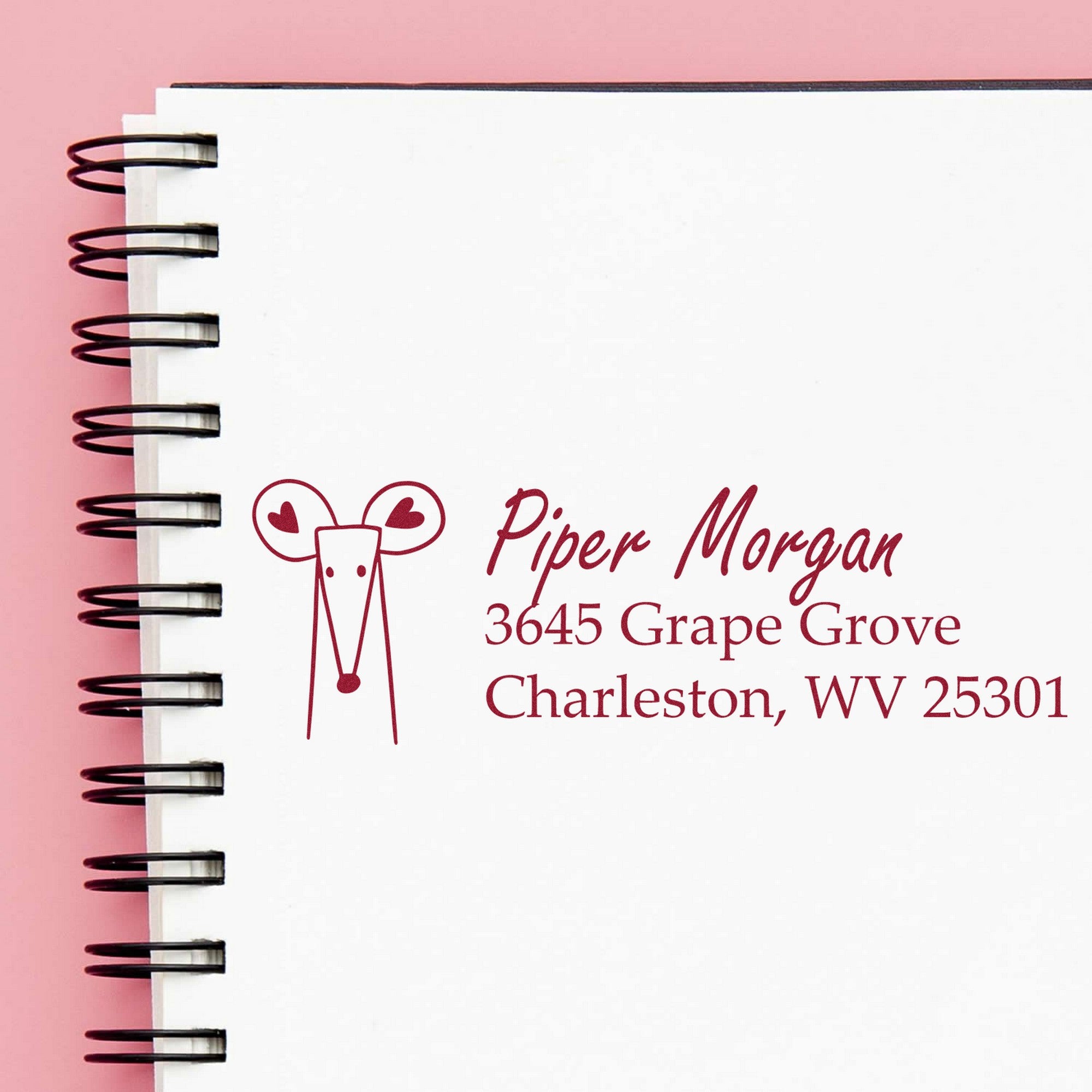 Wood Handle Mighty Mouse Handmade Address Label Rubber Stamp on a spiral notebook, featuring a personalizable return mail stamper design with a cute mouse illustration and sample address for Piper Morgan, 3645 Grape Grove, Charleston, WV 25301.