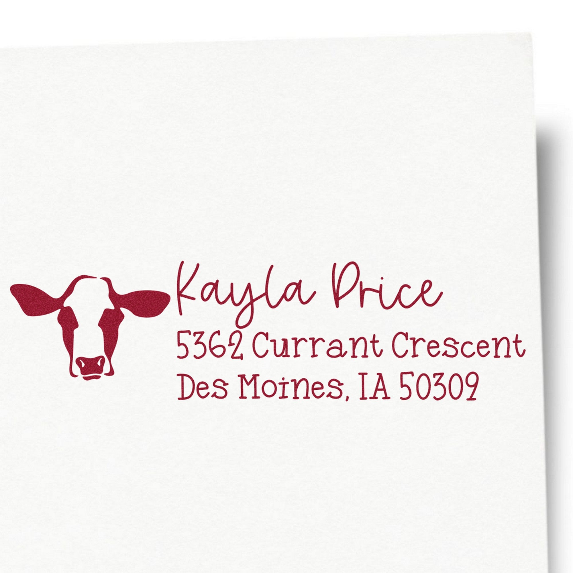 Maroon custom return address stamp with cow head seal icon, Kayla Price, and Des Moines, IA address on white background.