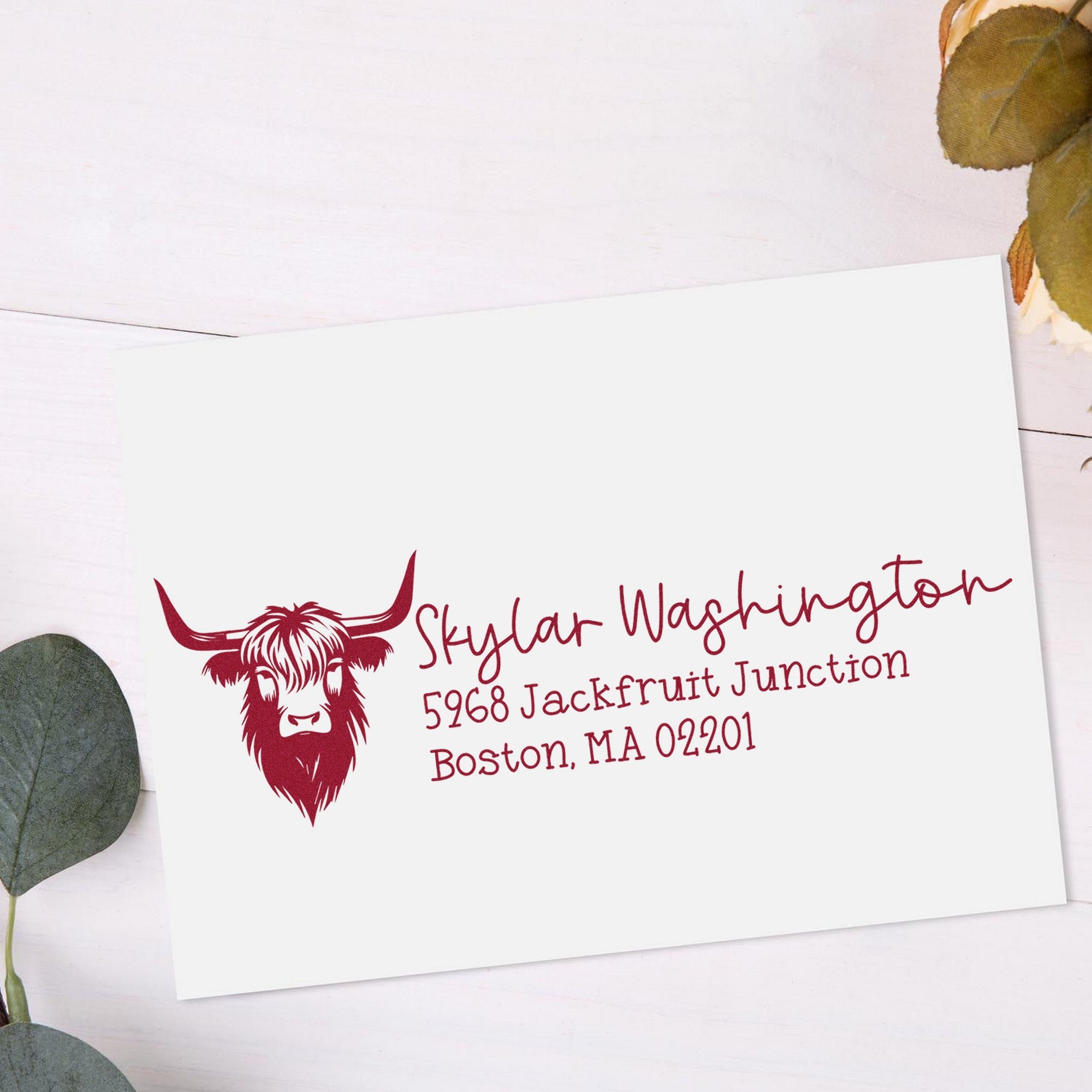 White custom return address stamp with burgundy longhorn cow logo and lettering for Skylar Washington, on a white envelope.