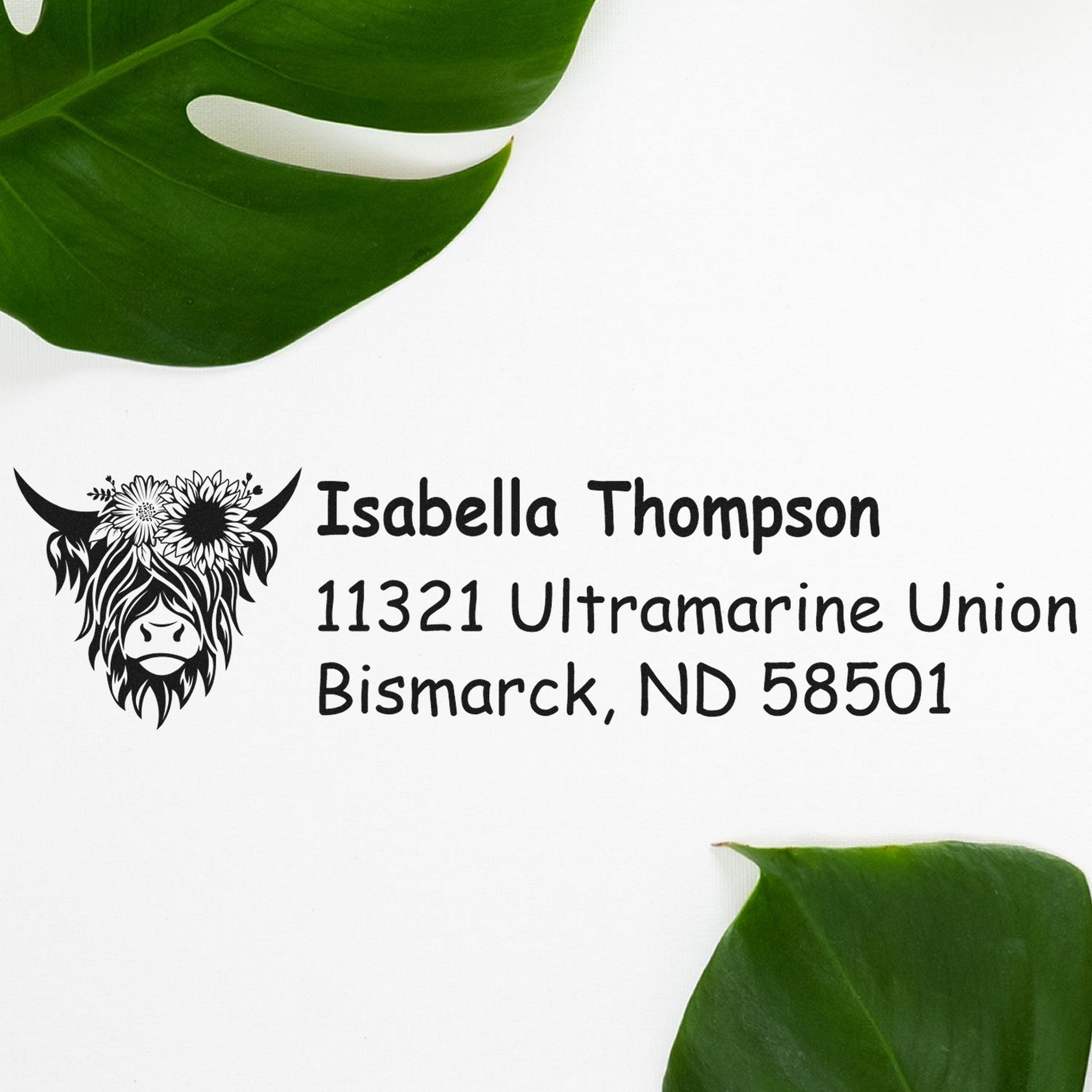 Custom black address stamp and seal with cow logo, Isabella Thompson, Bismarck, ND, on white with green leaves.