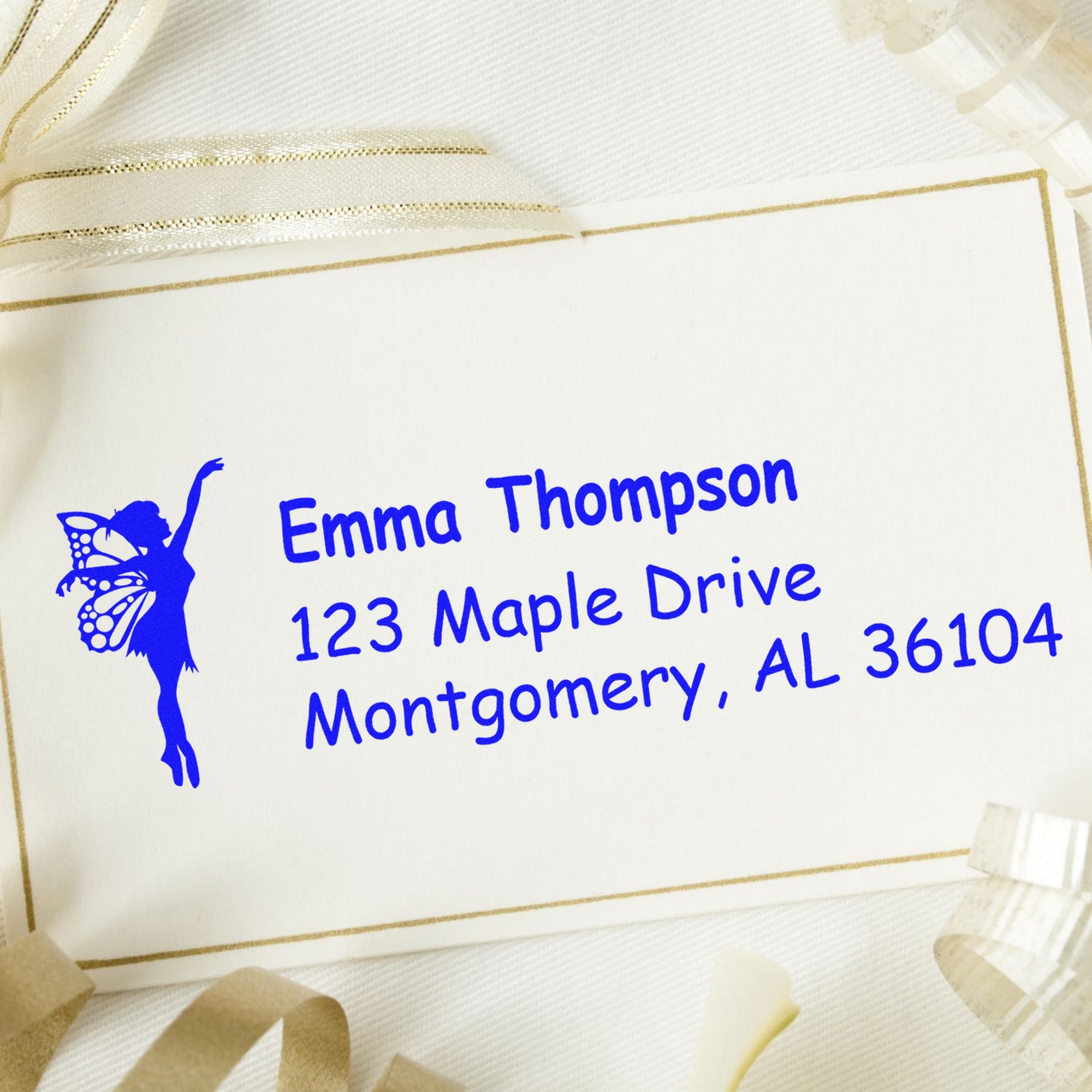 Custom blue fairy return address stamp and seal for Emma Thompson on cream stationery with gold trim.