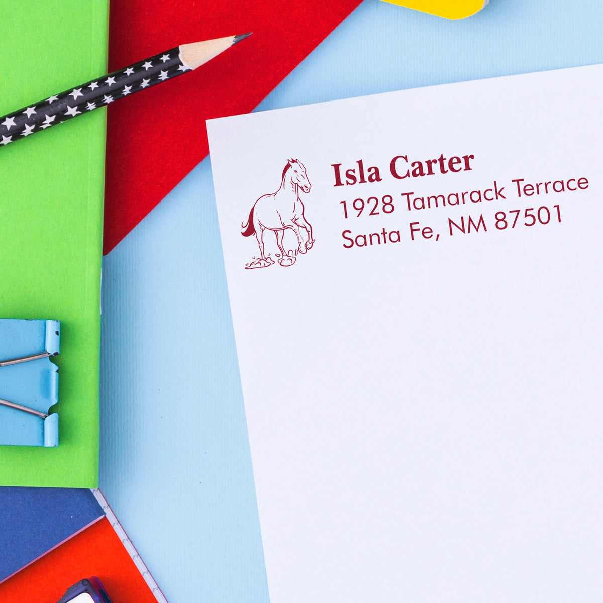 White envelope with burgundy horse address seal on colorful paper background, showcasing custom stamp and seal branding.