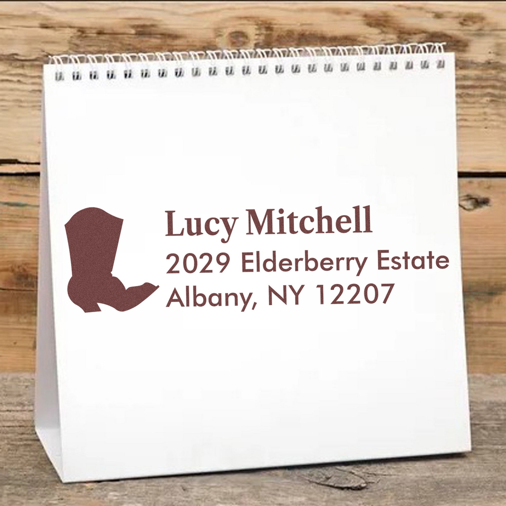White paper bag with brown custom return-address stamp and seal, name, address, and state silhouette.