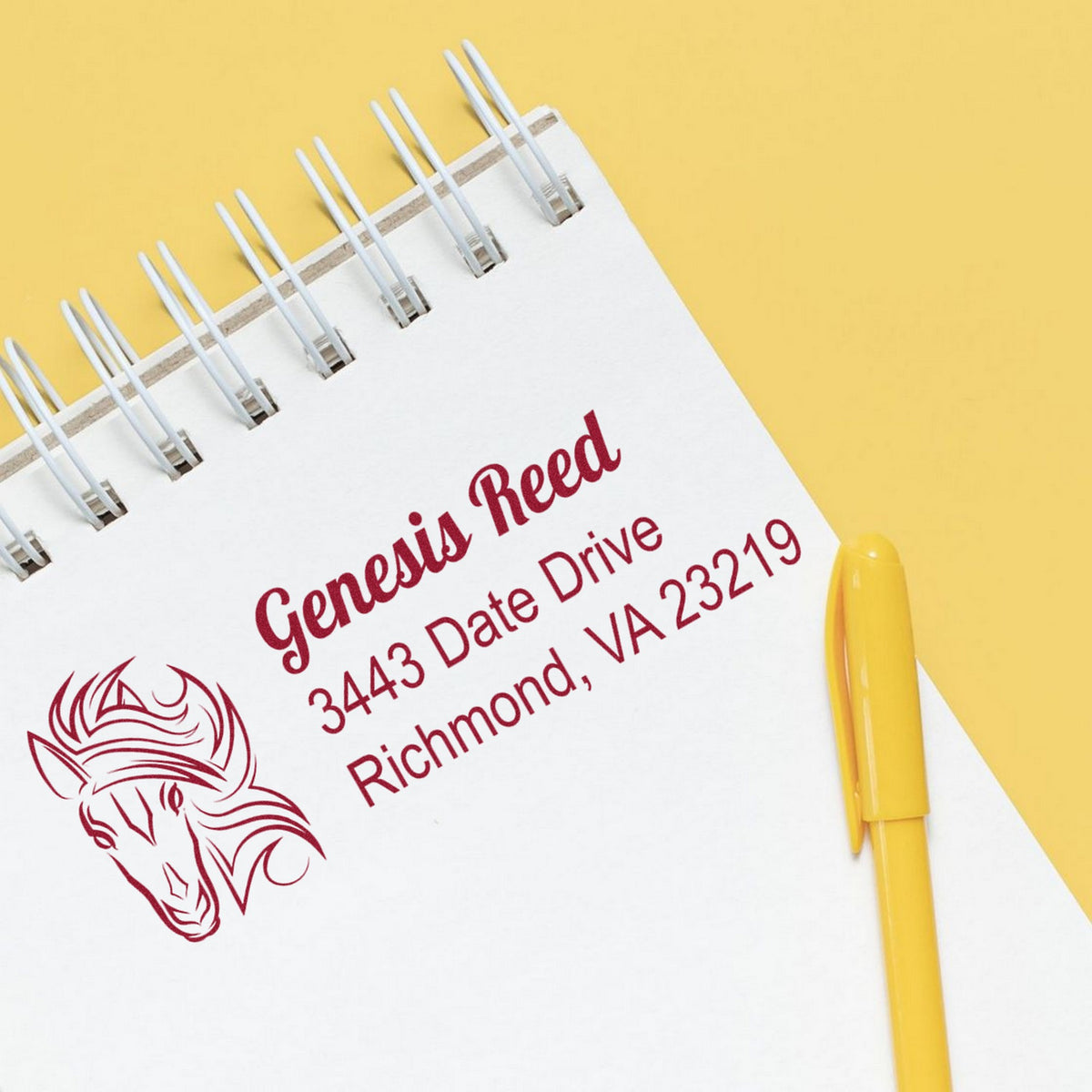 Custom burgundy stamp and seal on white spiral notebook with unicorn design, yellow pen, on a bright yellow background.