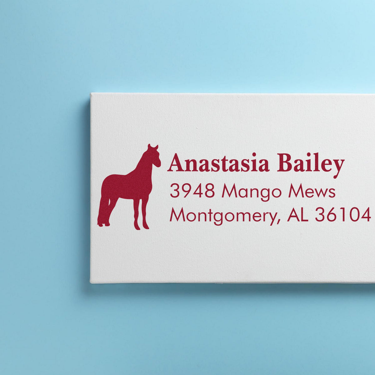 Custom red horse return address stamp and seal with Anastasia Bailey, Montgomery, AL on white paper, light blue background.