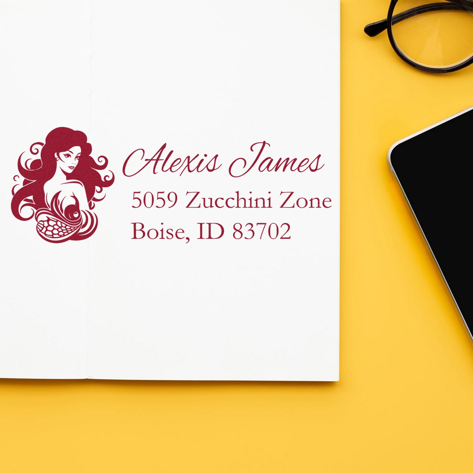 Maroon custom address stamp and seal with woman logo, Alexis James, on white paper beside black glasses on yellow background.
