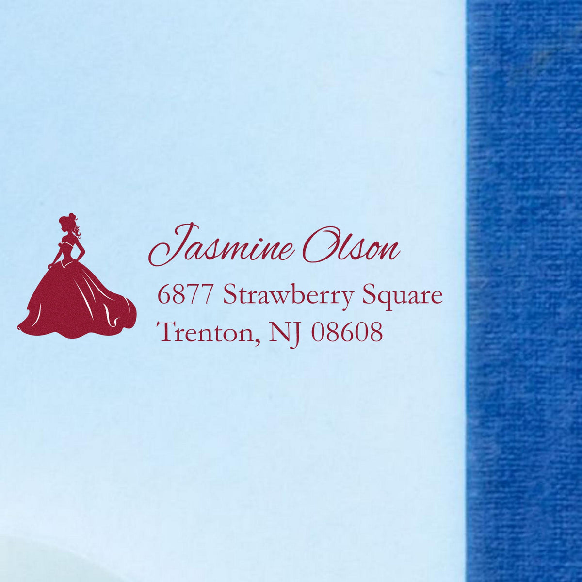 Custom red bridal silhouette stamp and address seal on white envelope against a blue background.
