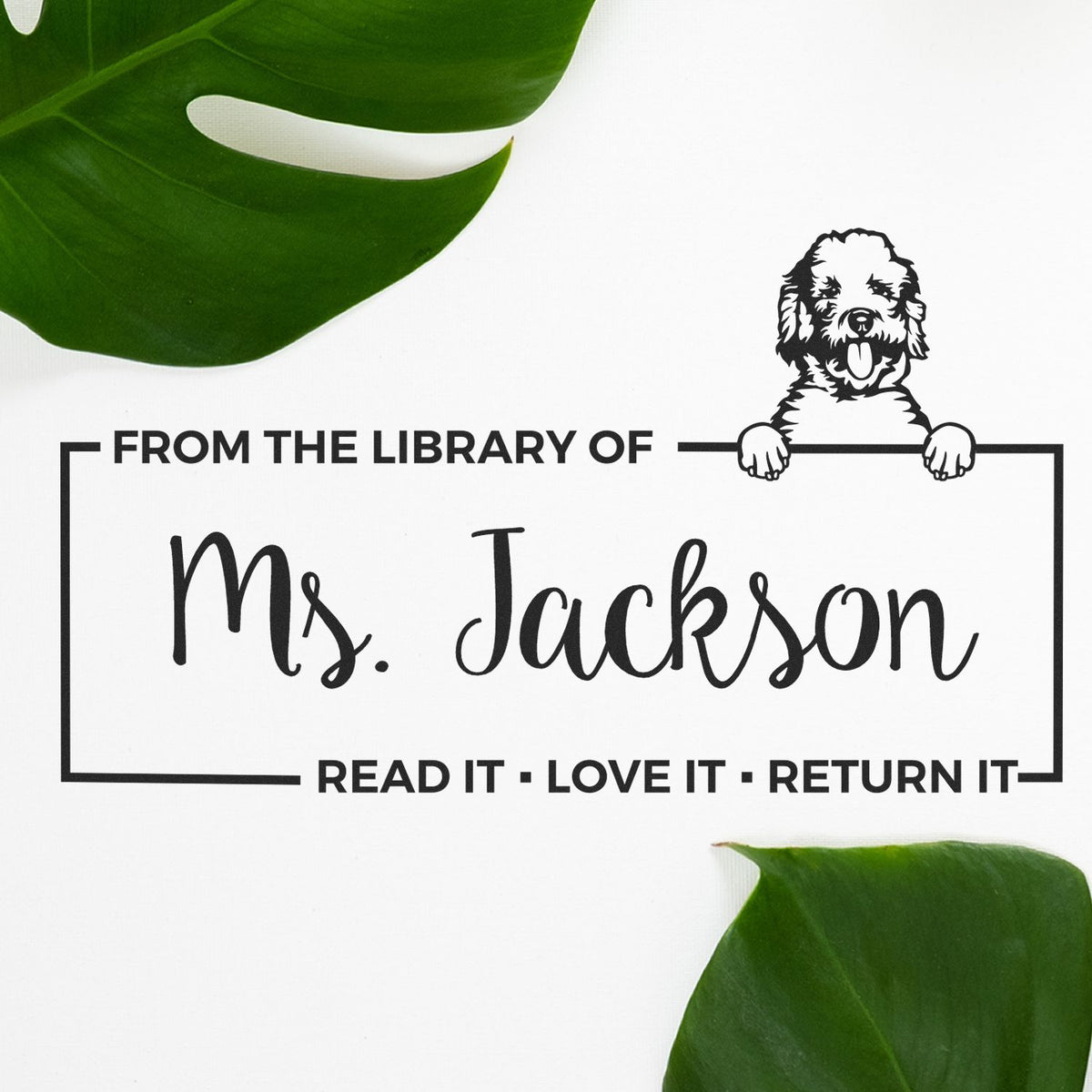 Black custom library stamp seal for Ms. Jackson with dog illustration on a white background and green leaves.