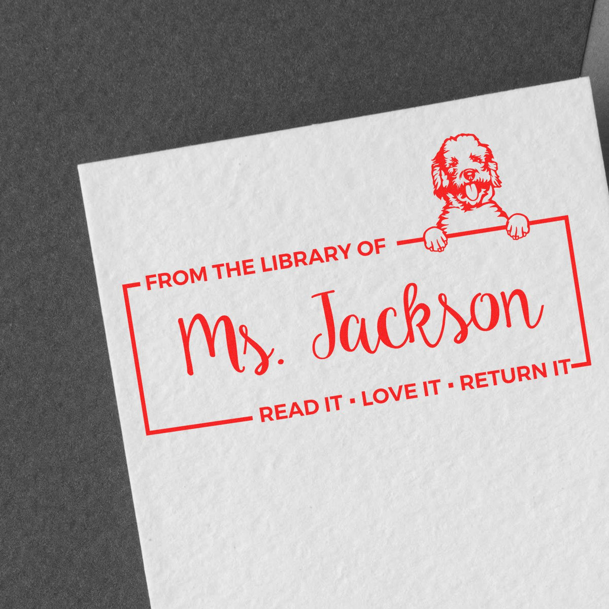 Red custom library stamp and dog seal on white paper, with Ms. Jackson and Read it, Love it, Return it in red.