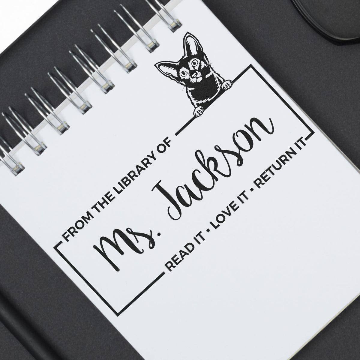 Black-and-white custom book stamp seal with cat design, reading From the library of Mrs. Jackson, read it, love it, return it.