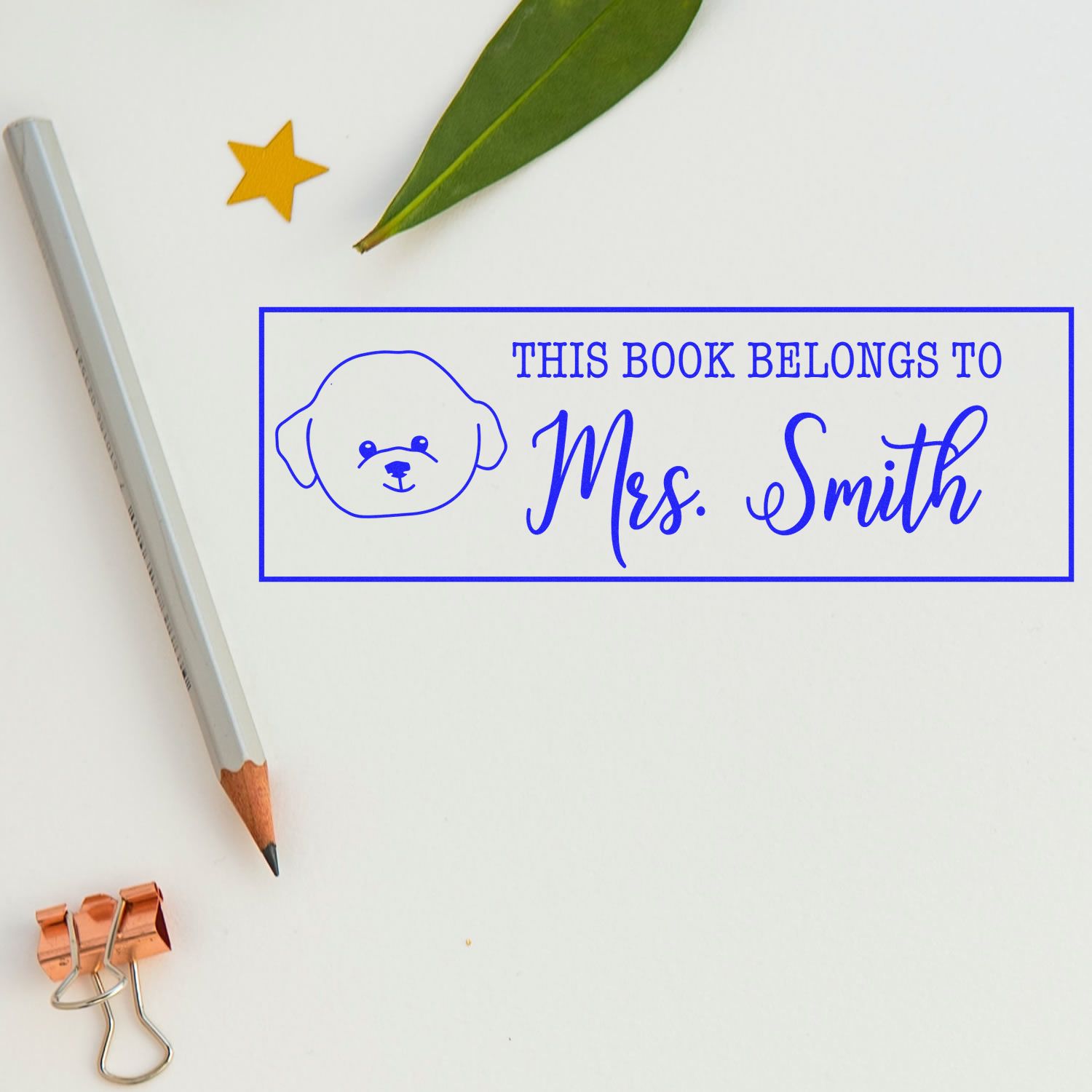 Blue custom book stamp and seal with dog icon, reading This book belongs to Mrs. Smith, on a white background.