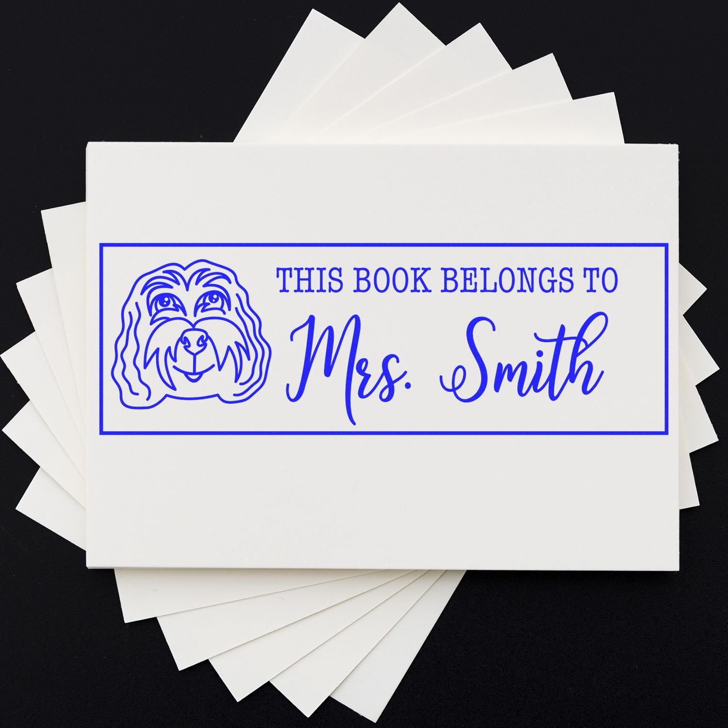 Blue custom bookplate stamp/seal with dog illustration and This Book Belongs to Mrs. Smith on white labels.