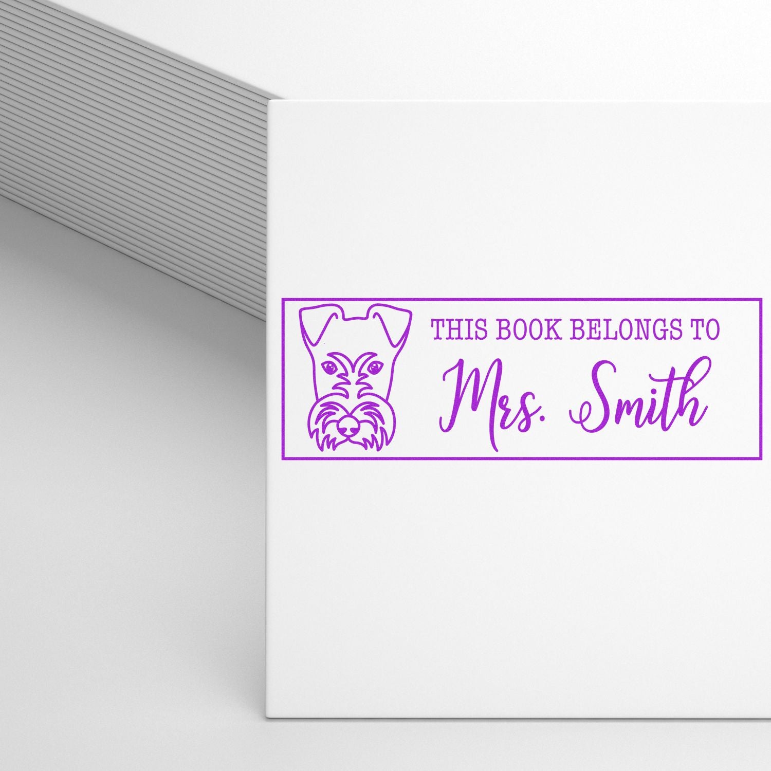 Purple personalized book stamp seal with dog outline and This Book Belongs to Mrs. Smith on white.