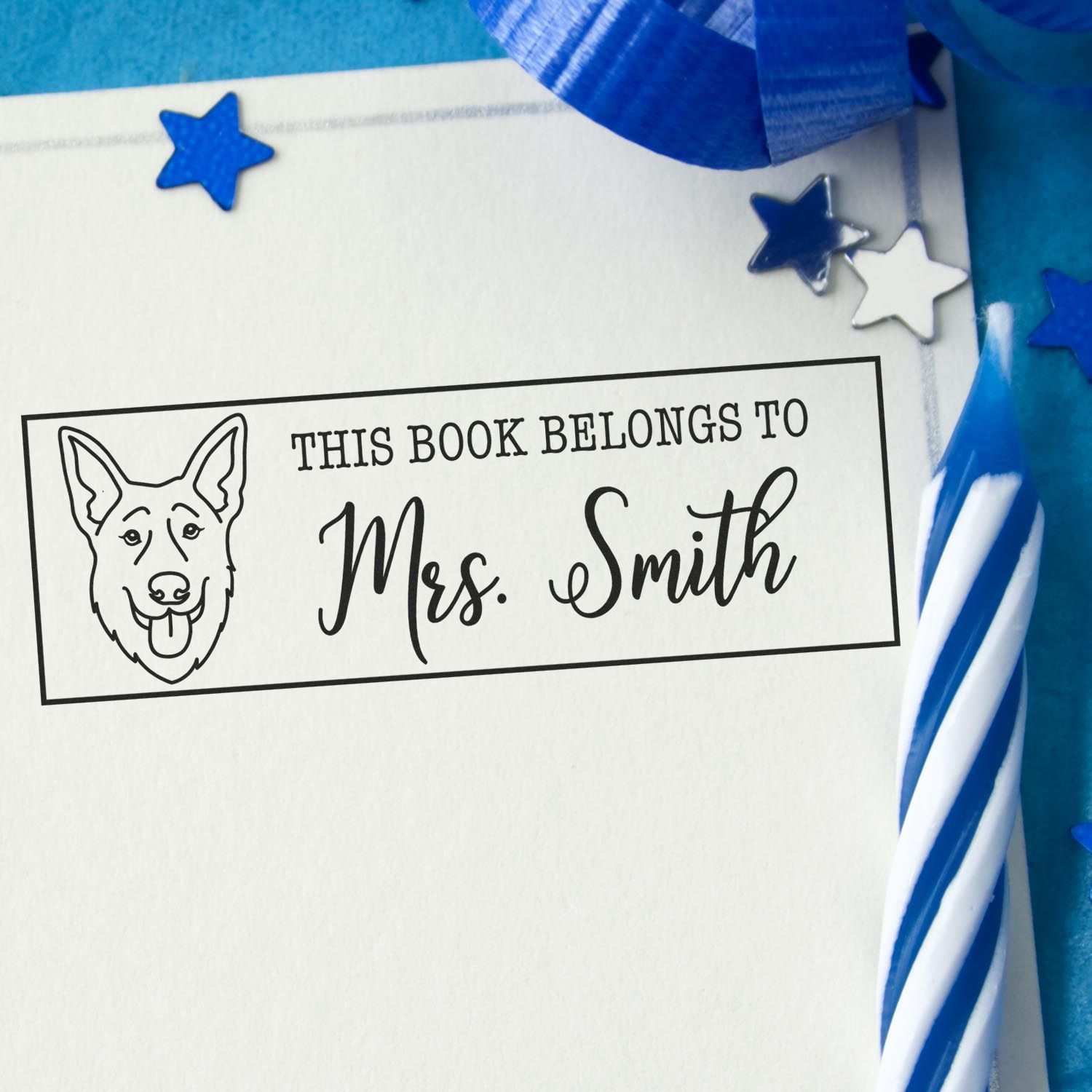 Blue and white personalized bookplate stamp seal with dog outline, Mrs. Smith text, and star accents on a bright blue background.