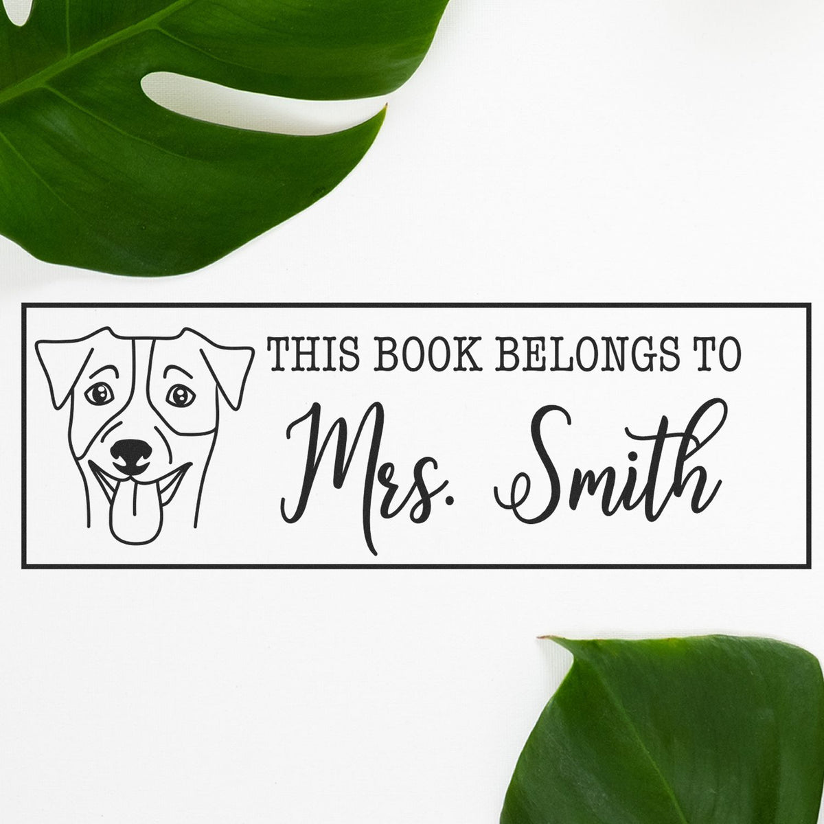 Black custom book stamp and seal with dog illustration and Mrs. Smith text on white, framed by green leaves.