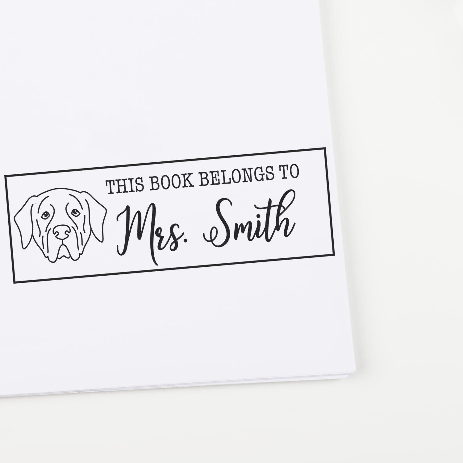 Black-and-white personalized book ownership stamp with dog illustration and This Book Belongs to Mrs. Smith text