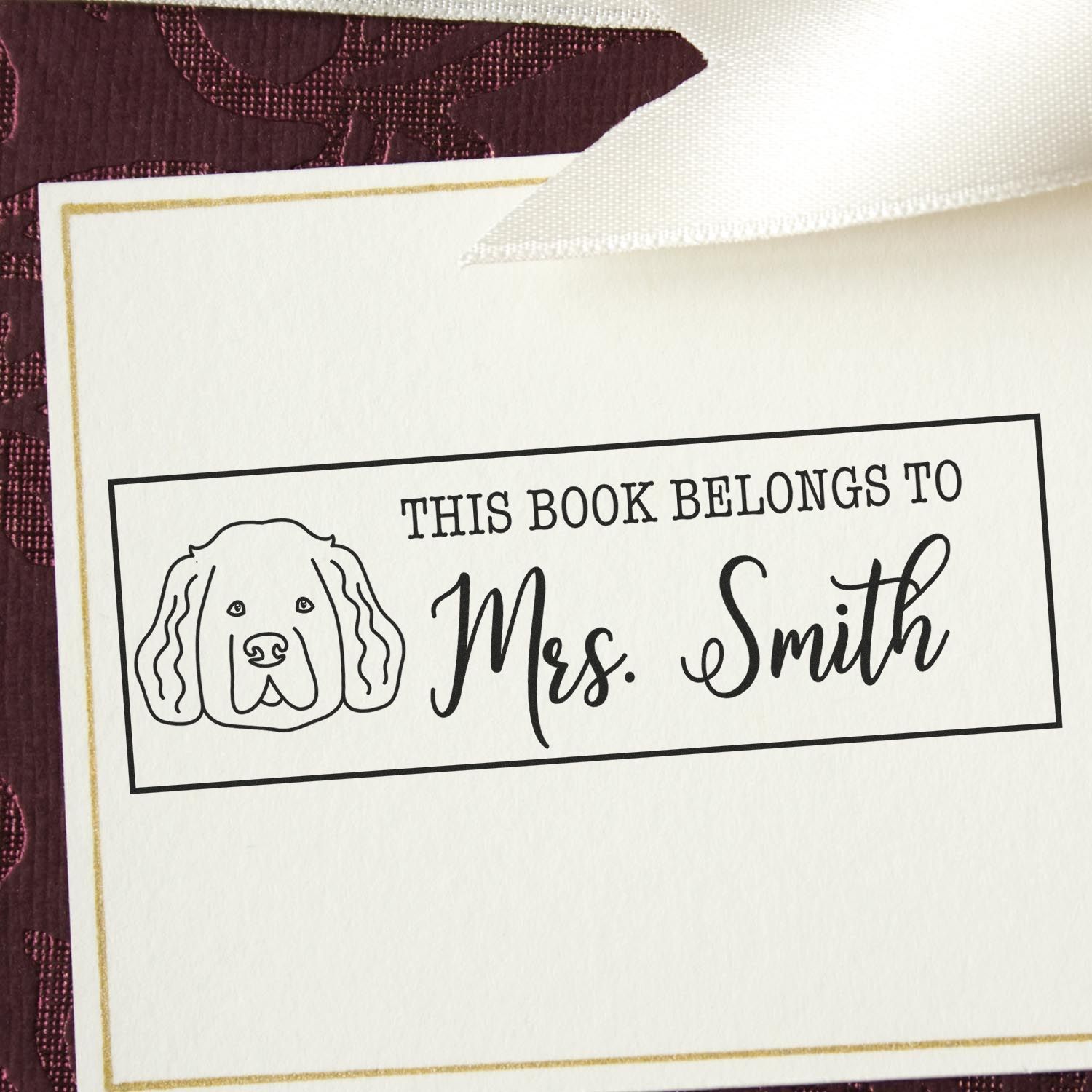 Personalized book stamp and seal with dog icon, black text for Mrs. Smith, on white card with gold trim.