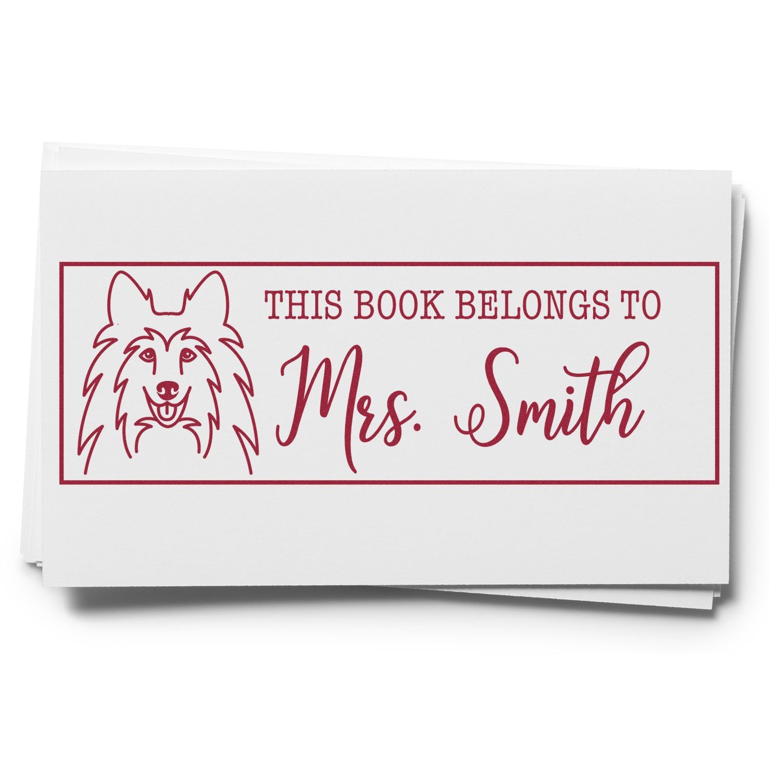 Burgundy custom book stamp seal with dog illustration and This Book Belongs to Mrs. Smith on white paper.