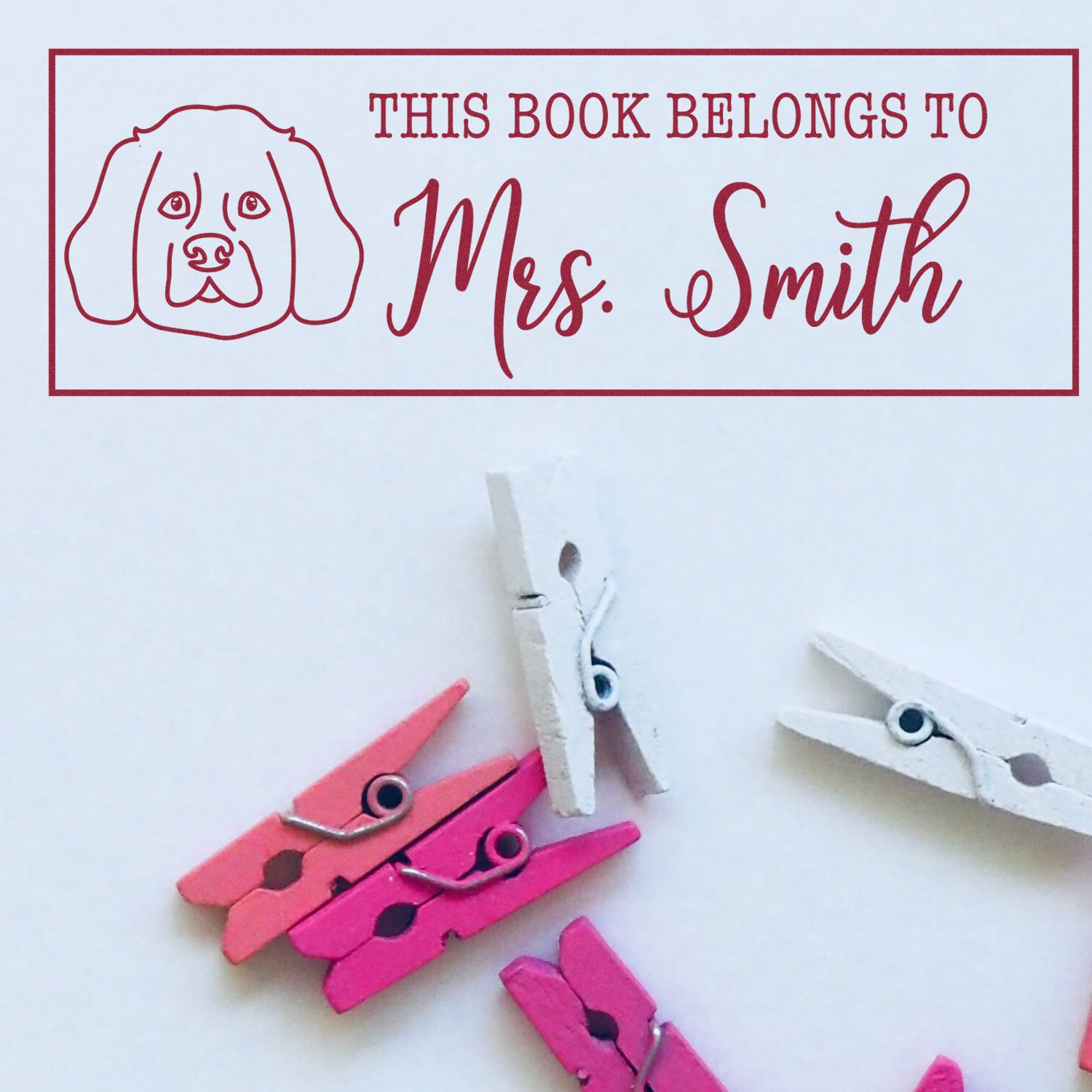 Red personalized book stamp and seal with dog icon, This Book Belongs to Mrs. Smith, and pink, white mini clothespins.