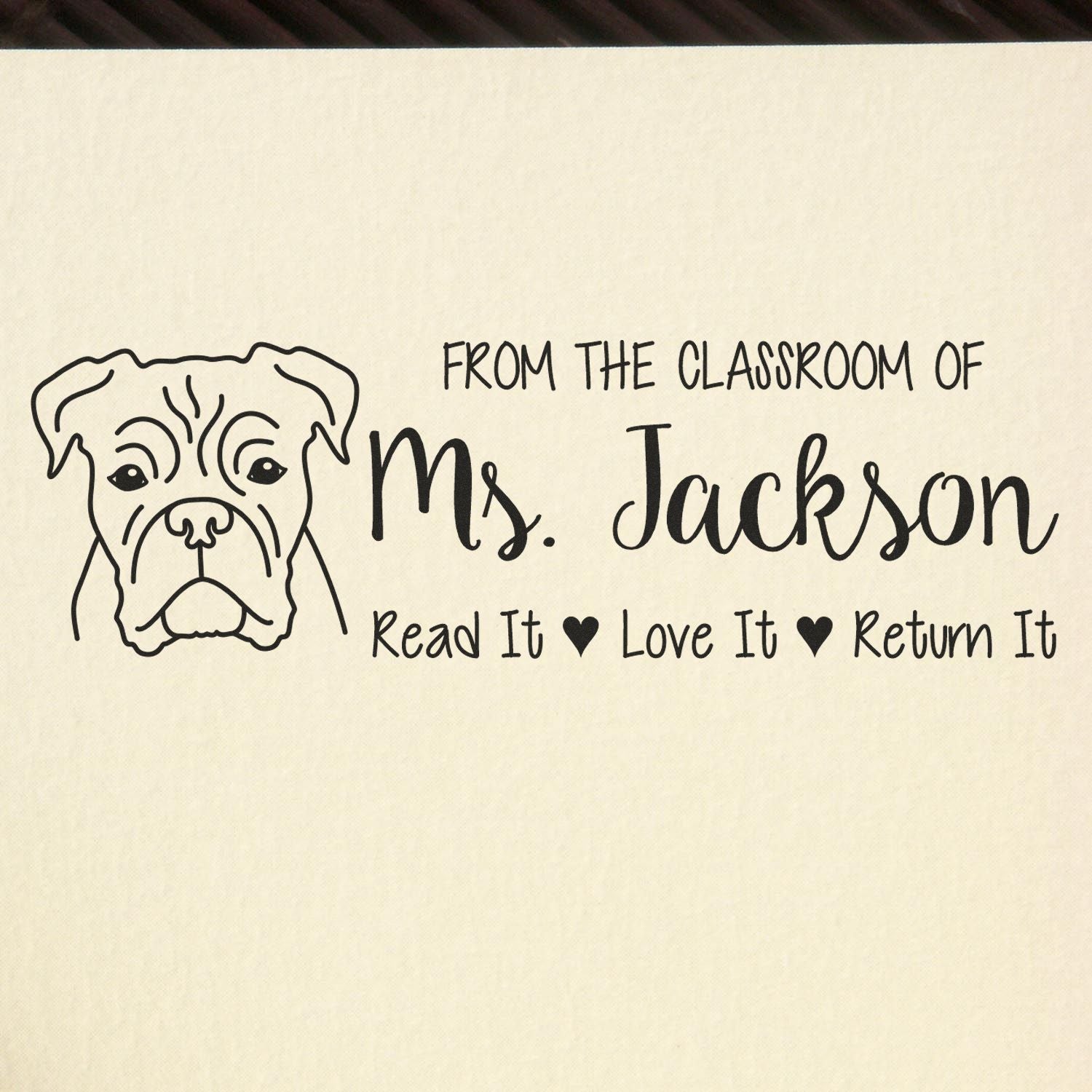 Black classroom stamp with bulldog outline and text for Ms. Jackson: Read It, Love It, Return It on cream background.