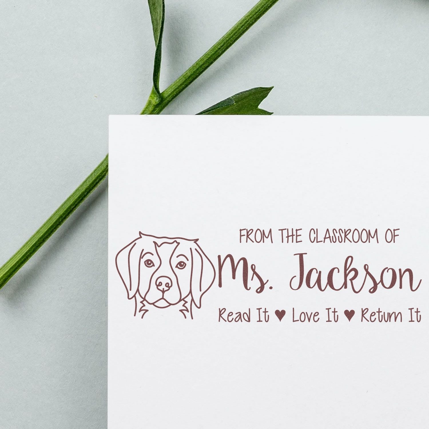Brown custom classroom stamp seal with dog line art and From the Classroom of Mrs. Jackson plus Read It Love It Return It on white card.