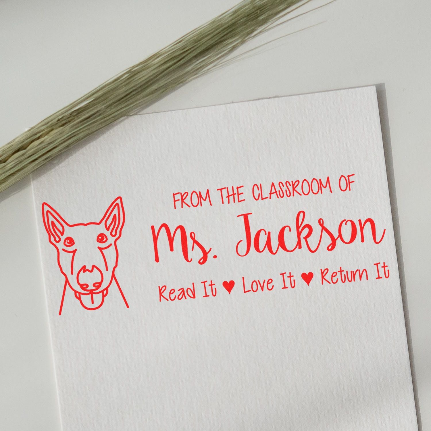 Red custom stamp on white card with dog outline, Ms. Jackson, and Read It, Love It, Return It text.