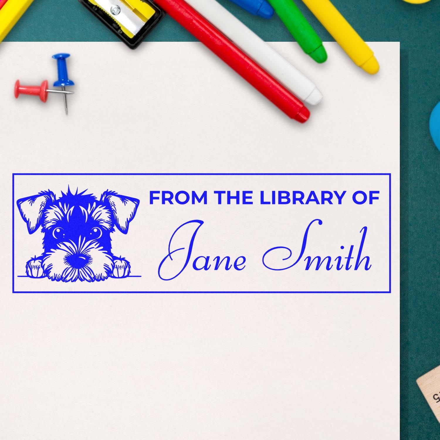 Blue custom stamp and seal with dog graphic, From the Library of Jane Smith, on white paper with colorful pens.