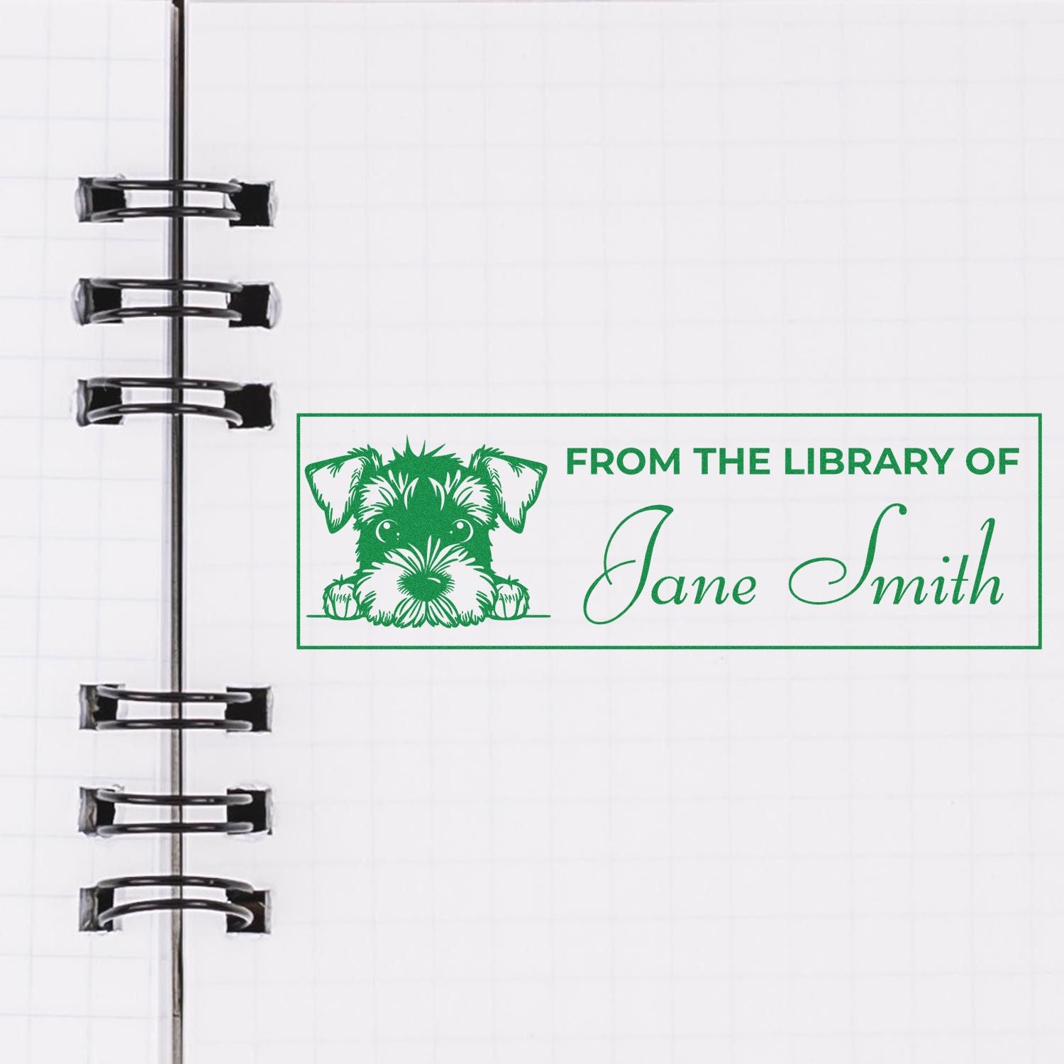 Green custom library stamp seal with dog and Jane Smith on white notebook page beside black binder rings