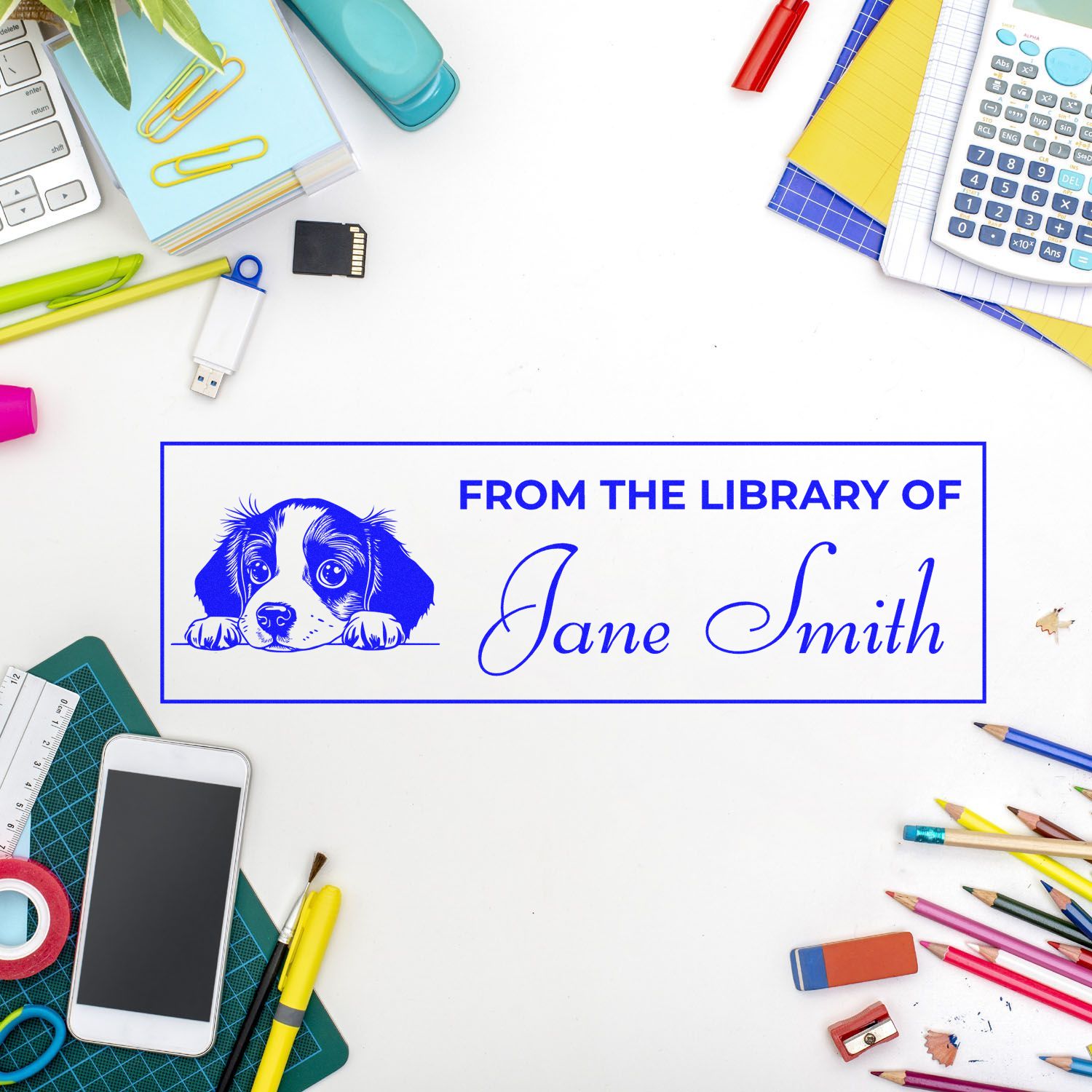 Blue custom library stamp seal with puppy and Jane Smith, surrounded by colorful stationery on a white desk.