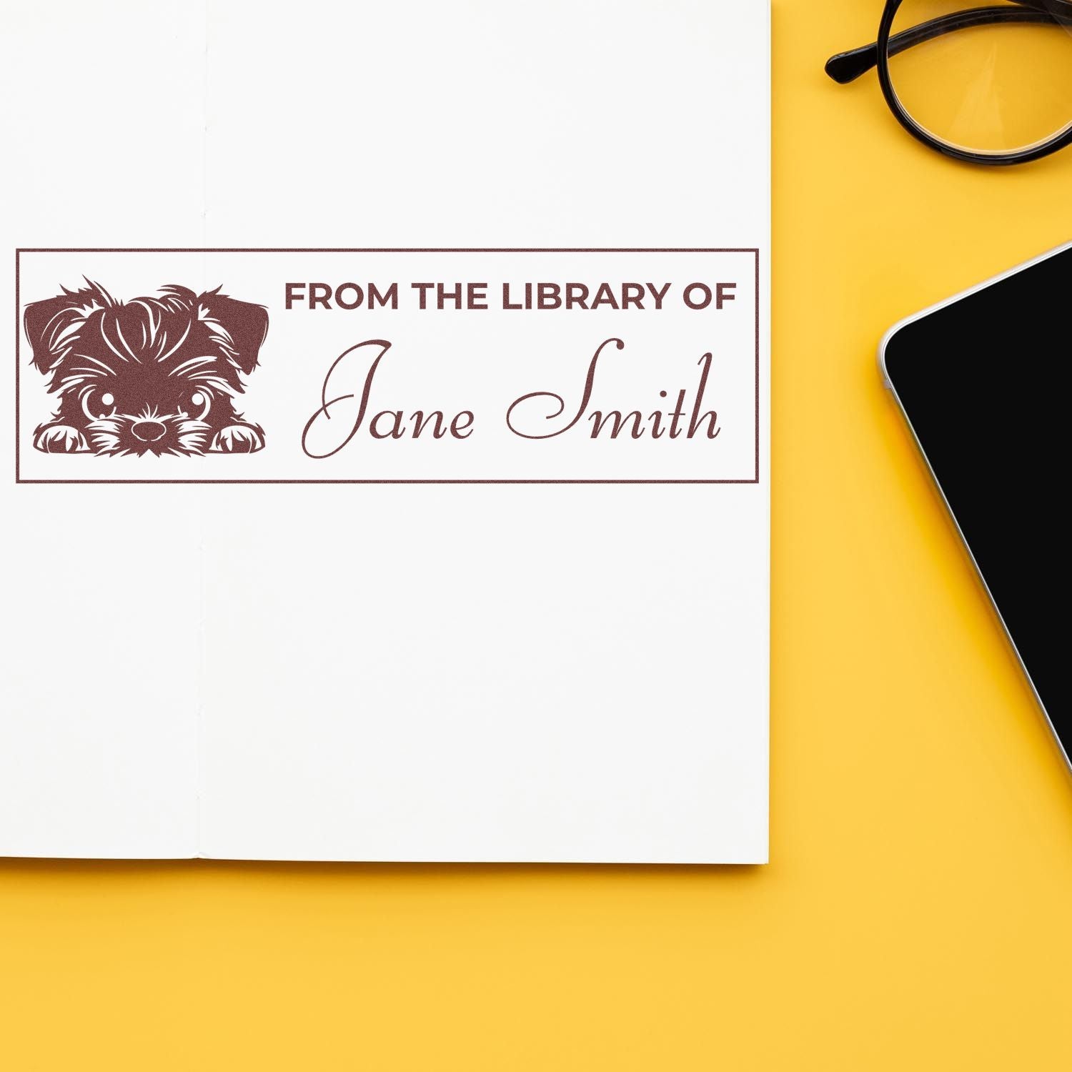 Brown custom library book stamp seal with dog graphic and Jane Smith on white paper, set against a bright yellow background.