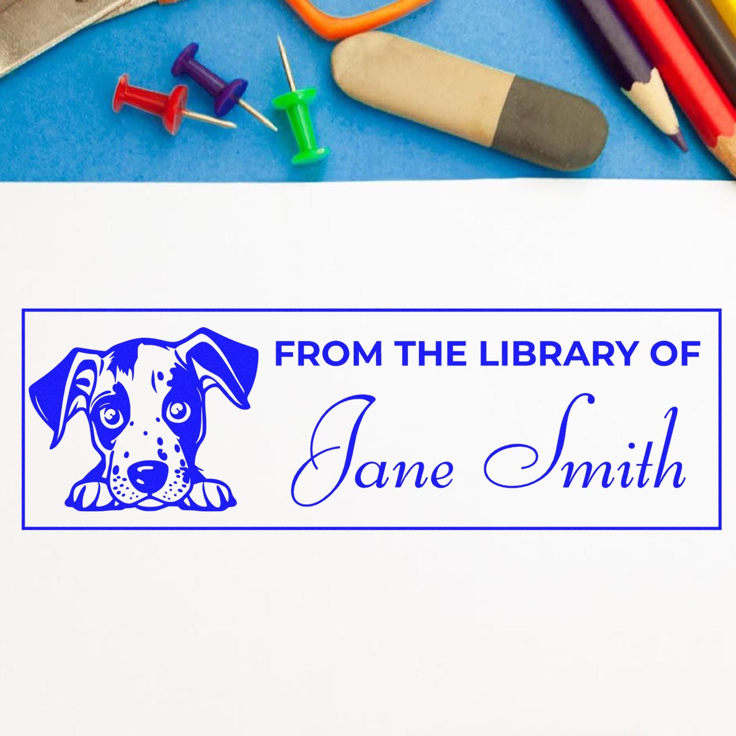 Blue custom library stamp and seal with dog graphic, Jane Smith name, on white paper with pencils and pushpins.
