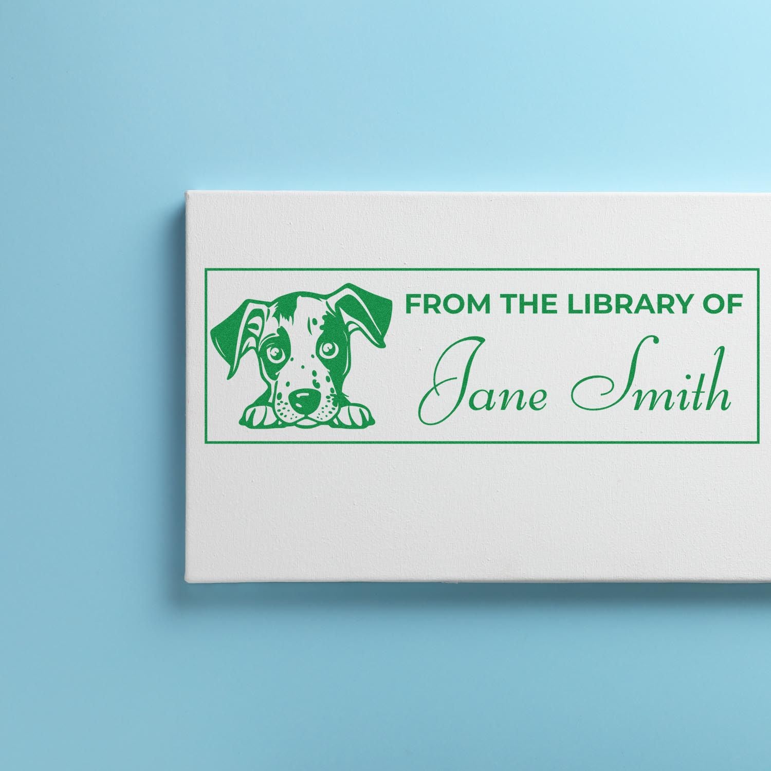 Green custom library stamp and seal with dog icon and Jane Smith text on a white block against a light blue background.