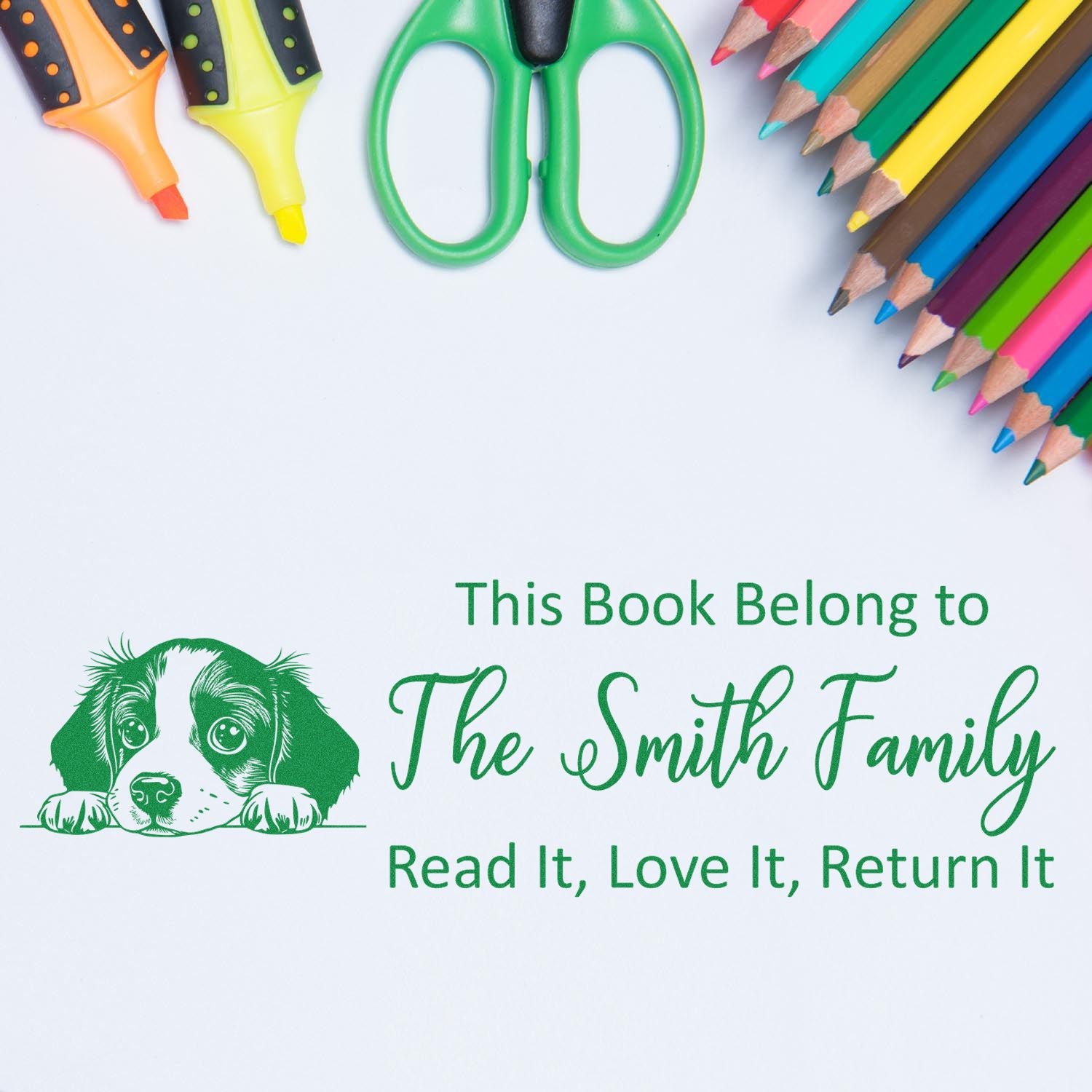 Green book ownership stamp seal with puppy and The Smith Family text, surrounded by colorful pencils, markers, and scissors.