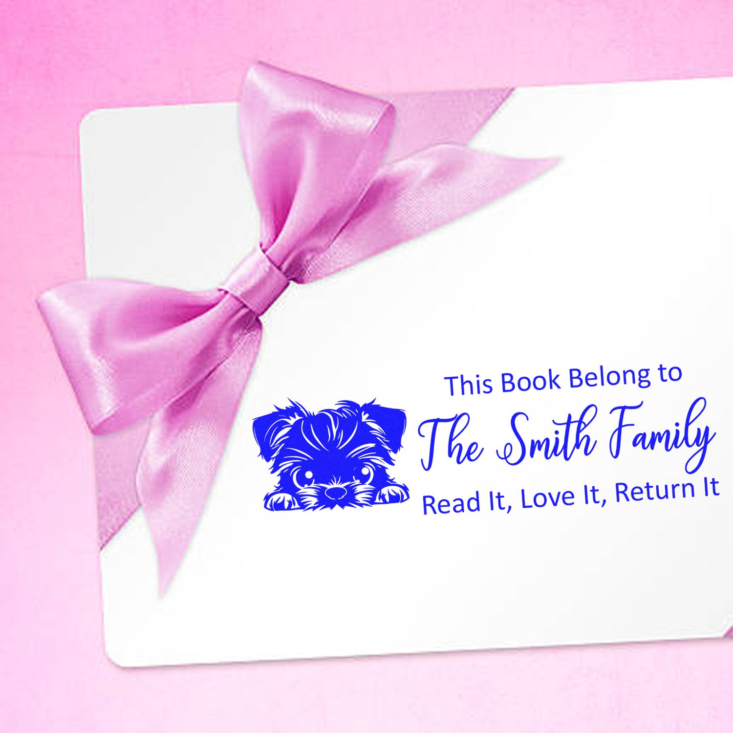 Custom blue bookplate stamp for The Smith Family with dog graphic, on white card tied with a pink satin bow.