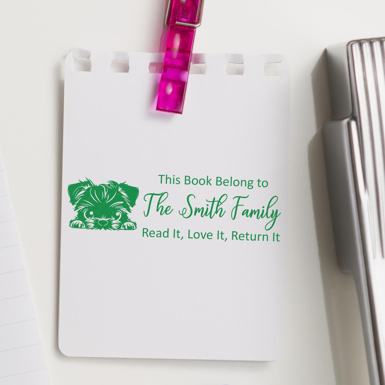 Green custom book stamp seal with dog icon and The Smith Family bookplate, clipped with a pink clip