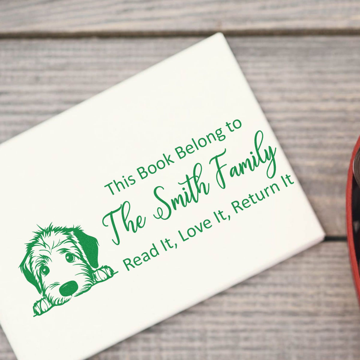 Green personalized book stamp seal with dog illustration and text: This Book Belong to The Smith Family, Read It, Love It, Return It
